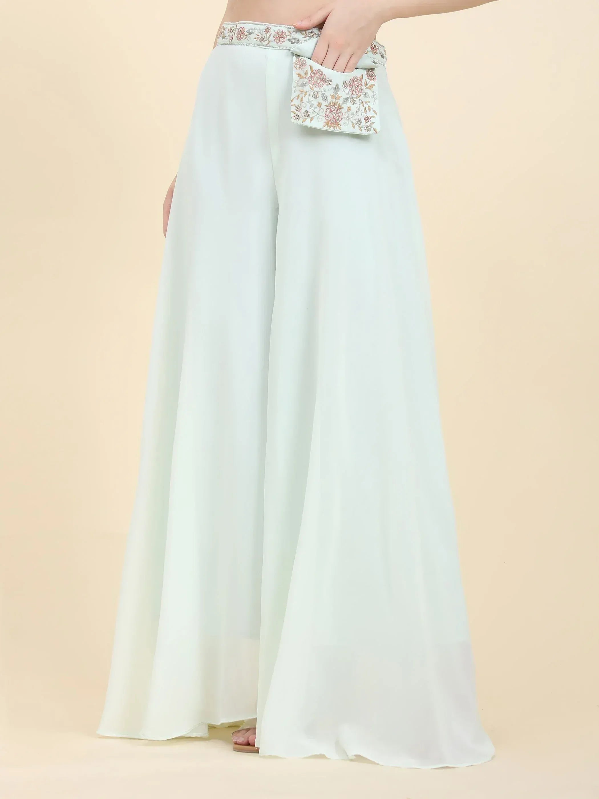 White palazzo pants with floral embroidered waistband and attached matching potli bag