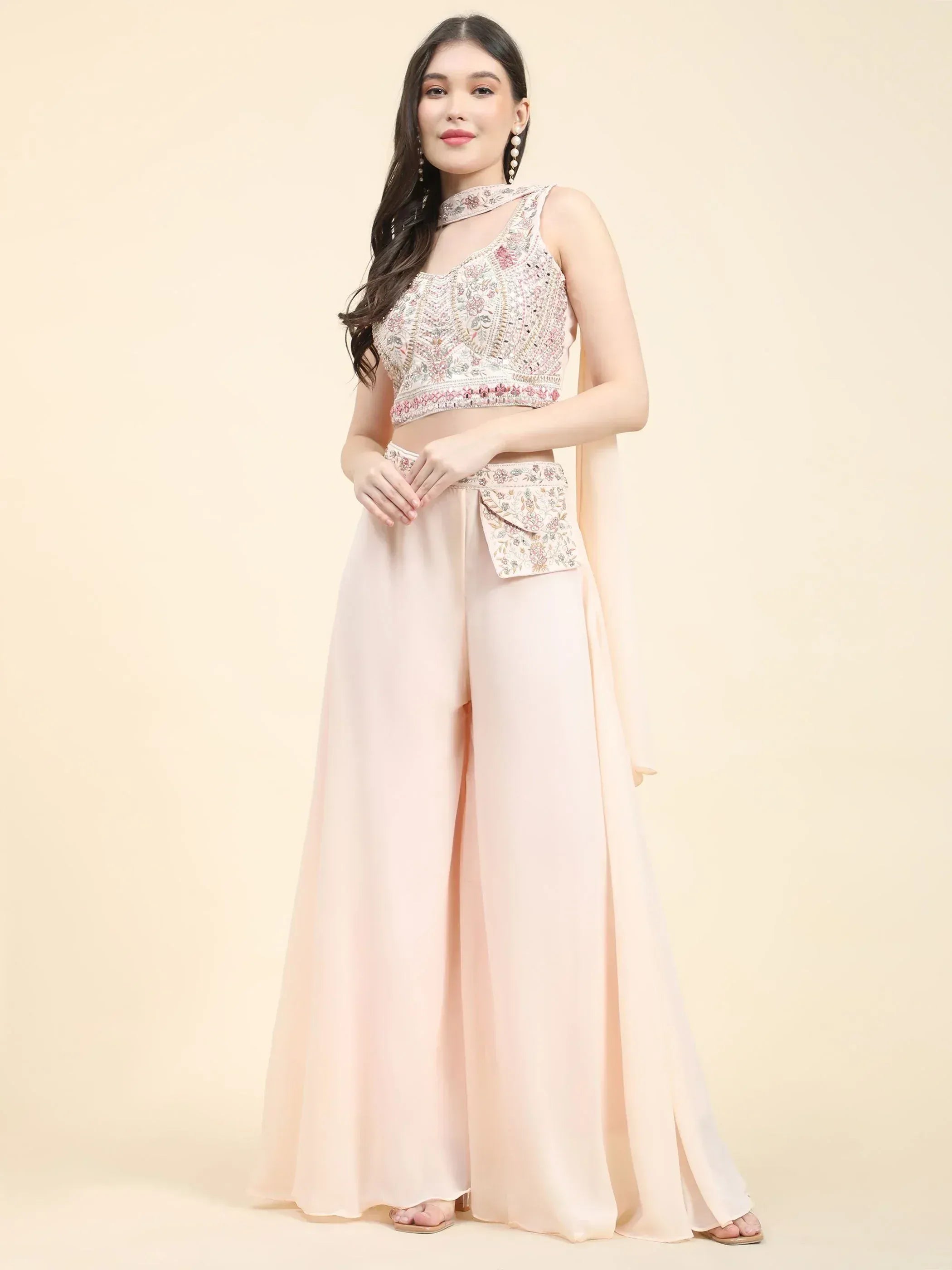 Woman in pastel embroidered ethnic crop top and palazzo set with dupatta, modern Indian wear