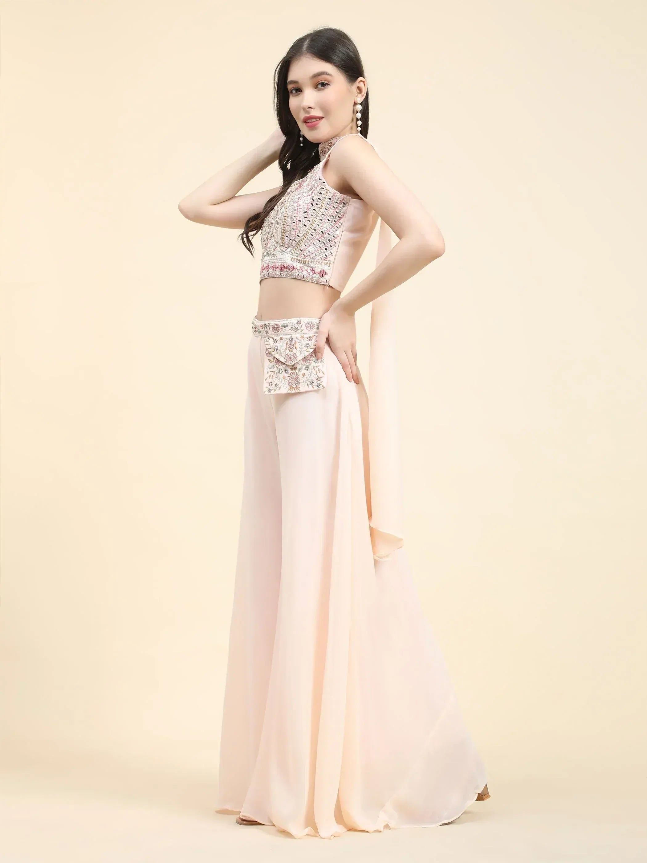 Woman in pastel pink Indo-western lehenga with embroidered crop top and flared palazzo pants