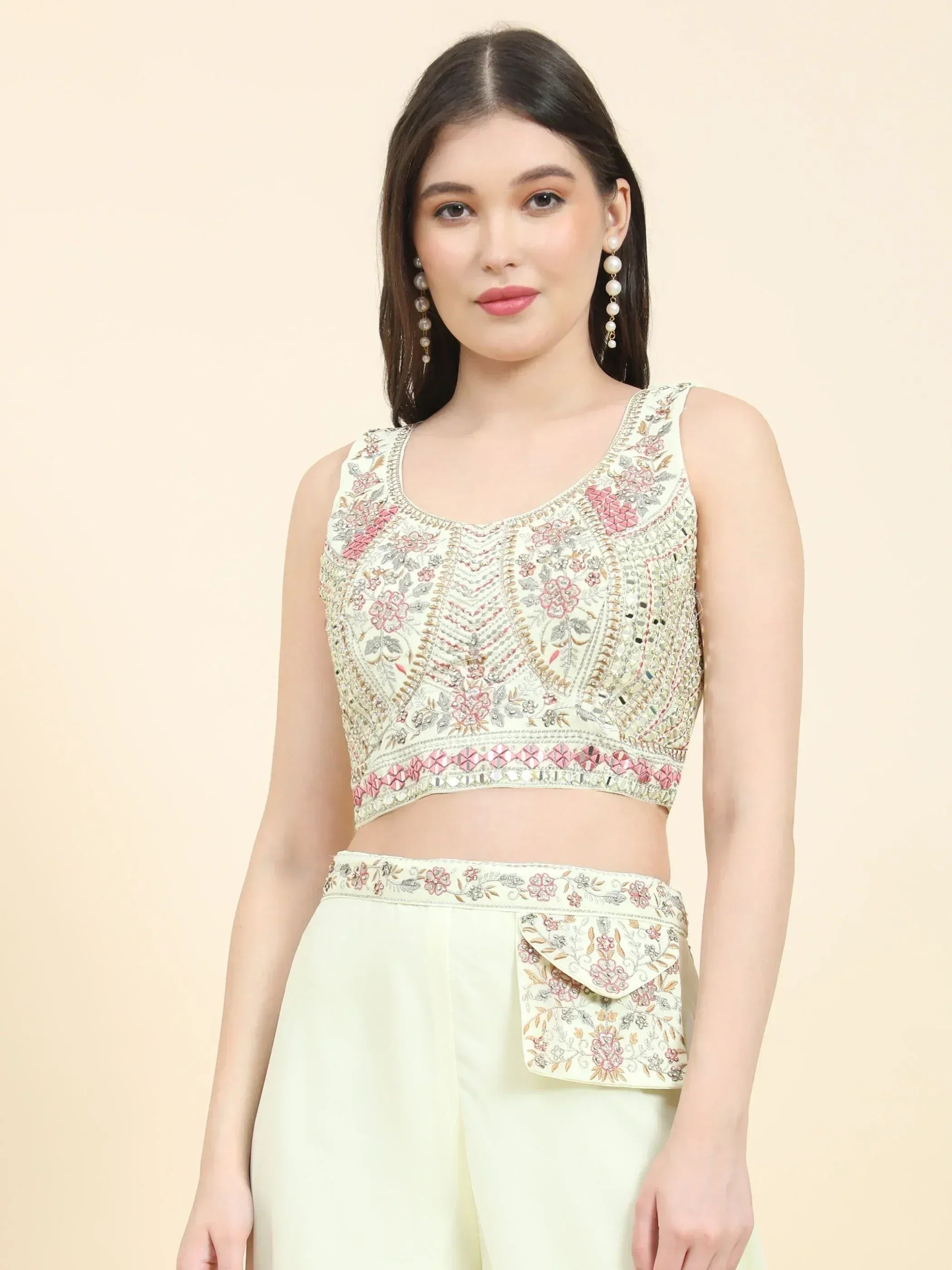 Woman wearing cream embroidered crop top and matching ethnic pants with floral designs