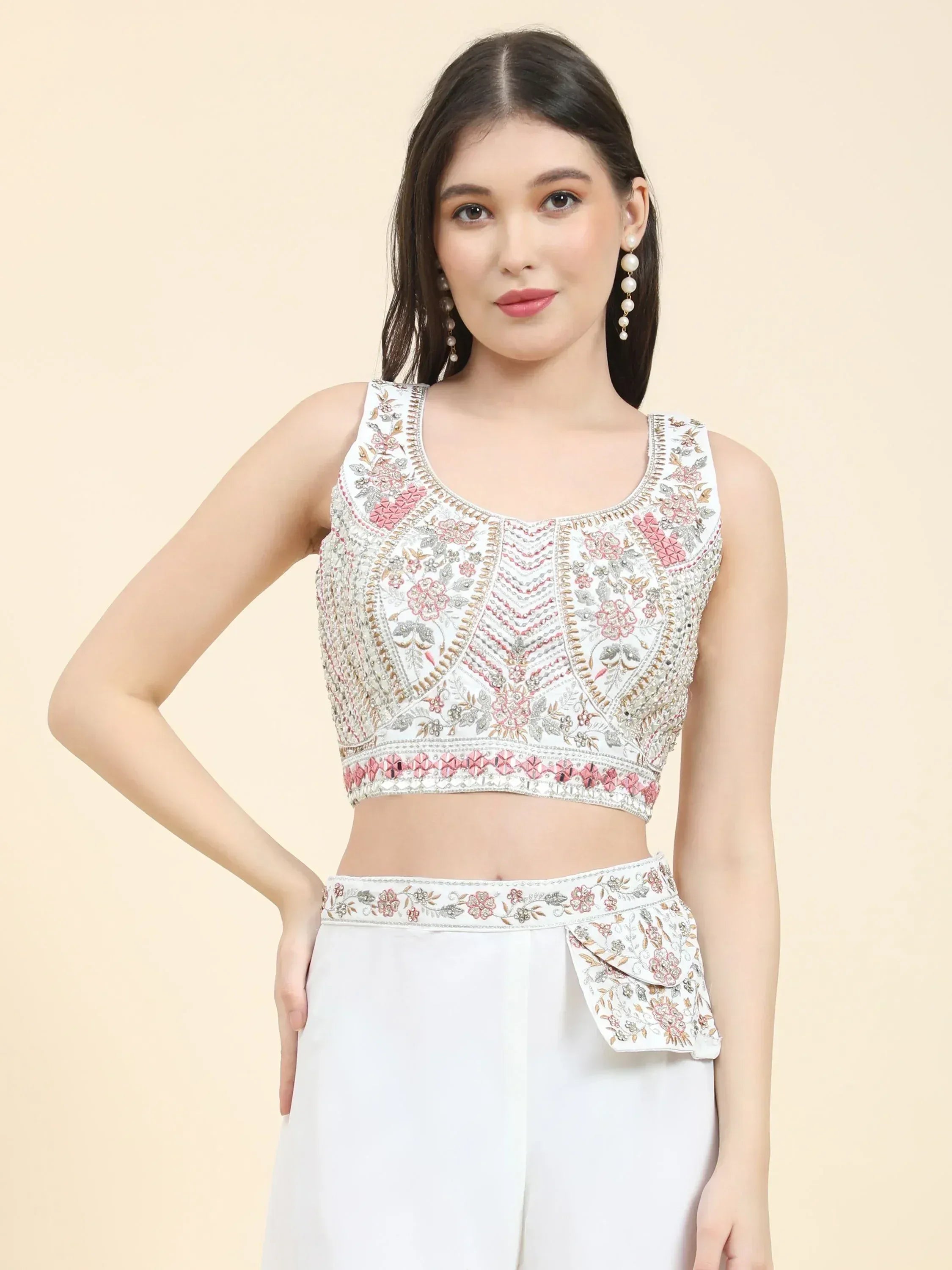 Woman in white embroidered crop top and palazzo, featuring floral ethnic Indian wear style