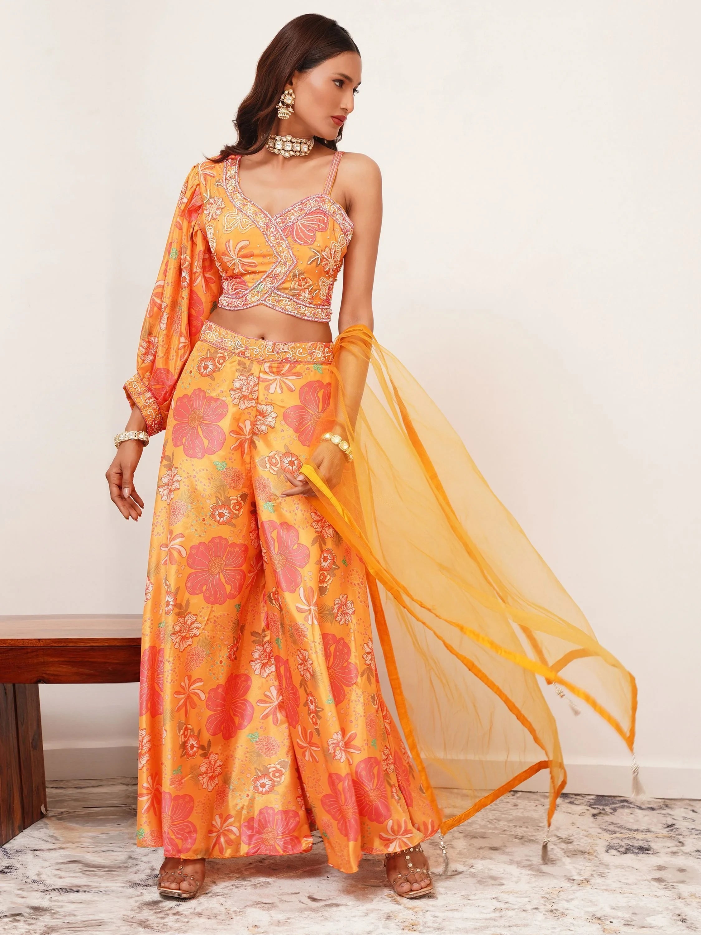 Woman in orange floral printed ethnic lehenga choli with dupatta and statement jewelry