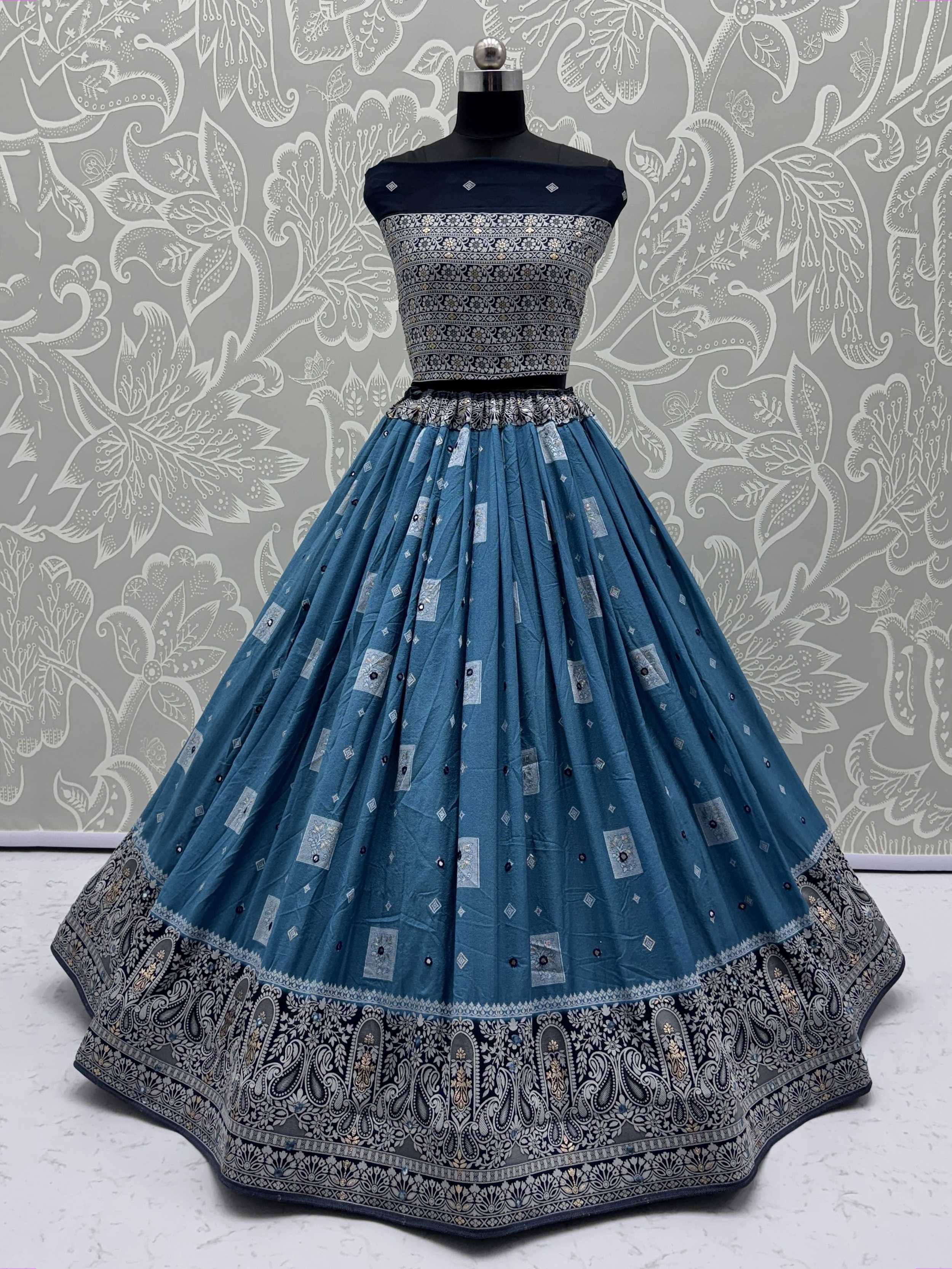Blue designer lehenga choli with intricate silver embroidery and paisley border, perfect for Indian ethnic wear.
