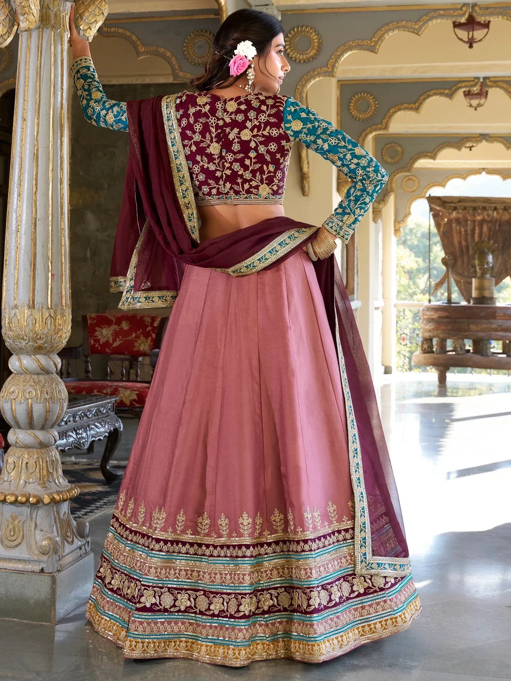 Elegant maroon and teal embroidered lehenga choli with gold detailing, perfect for Indian weddings and festive occasions.