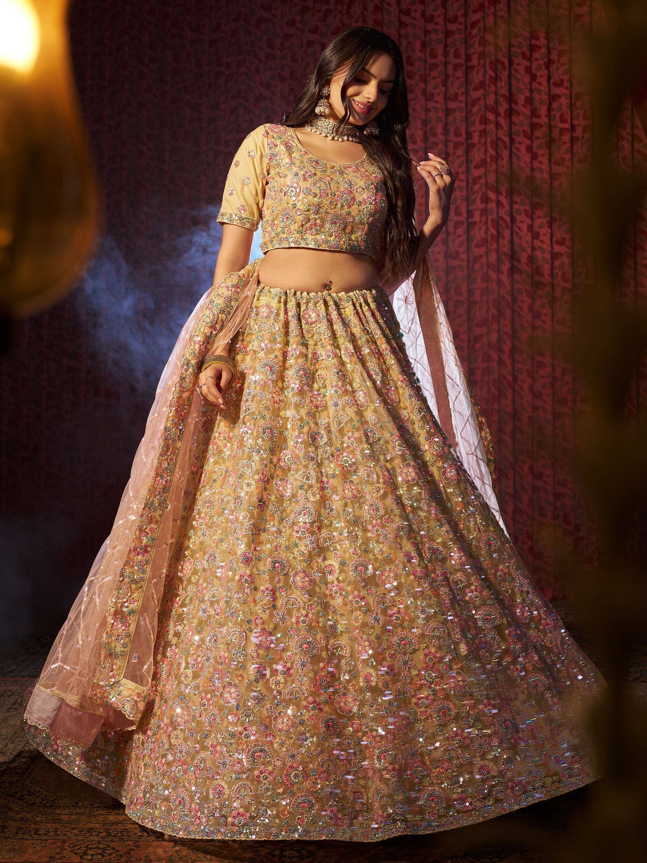 Elegant gold lehenga choli with floral embroidery and sequins, perfect for Indian weddings and festive occasions.