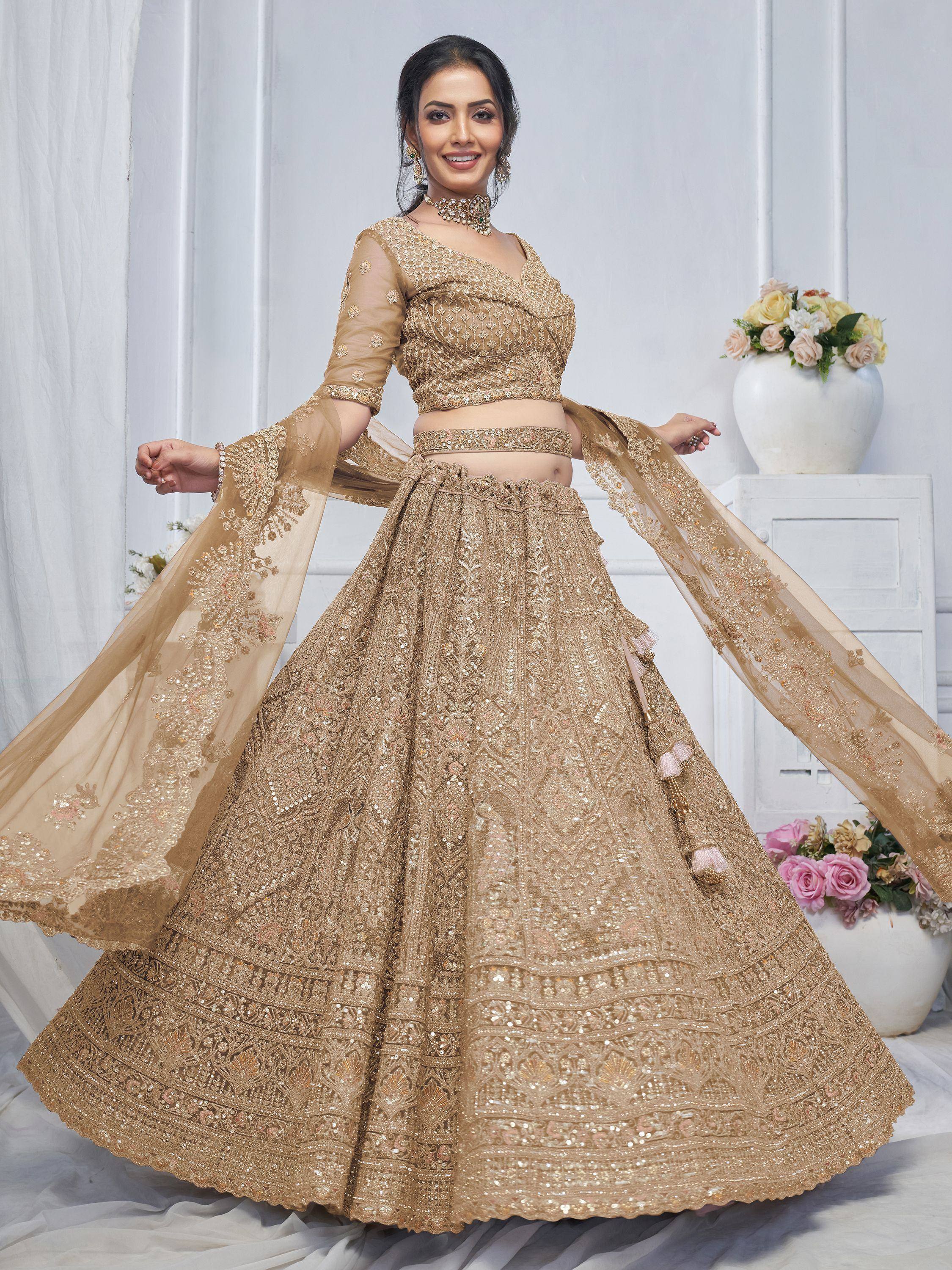 Elegant gold embroidered lehenga choli with sheer dupatta, perfect for Indian weddings and festive occasions.