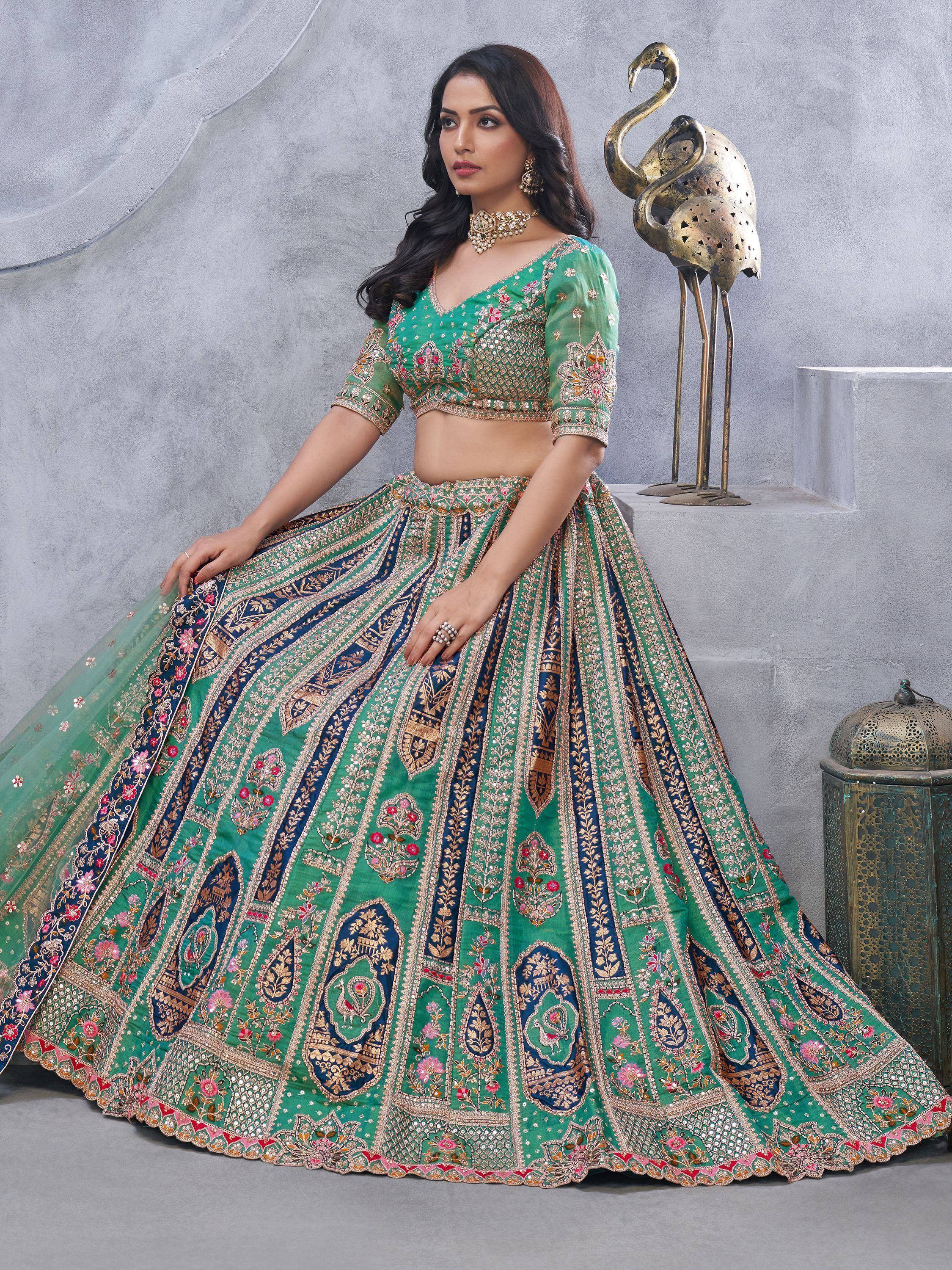 Green and blue embroidered lehenga choli with floral motifs, perfect for Indian weddings and festive occasions.