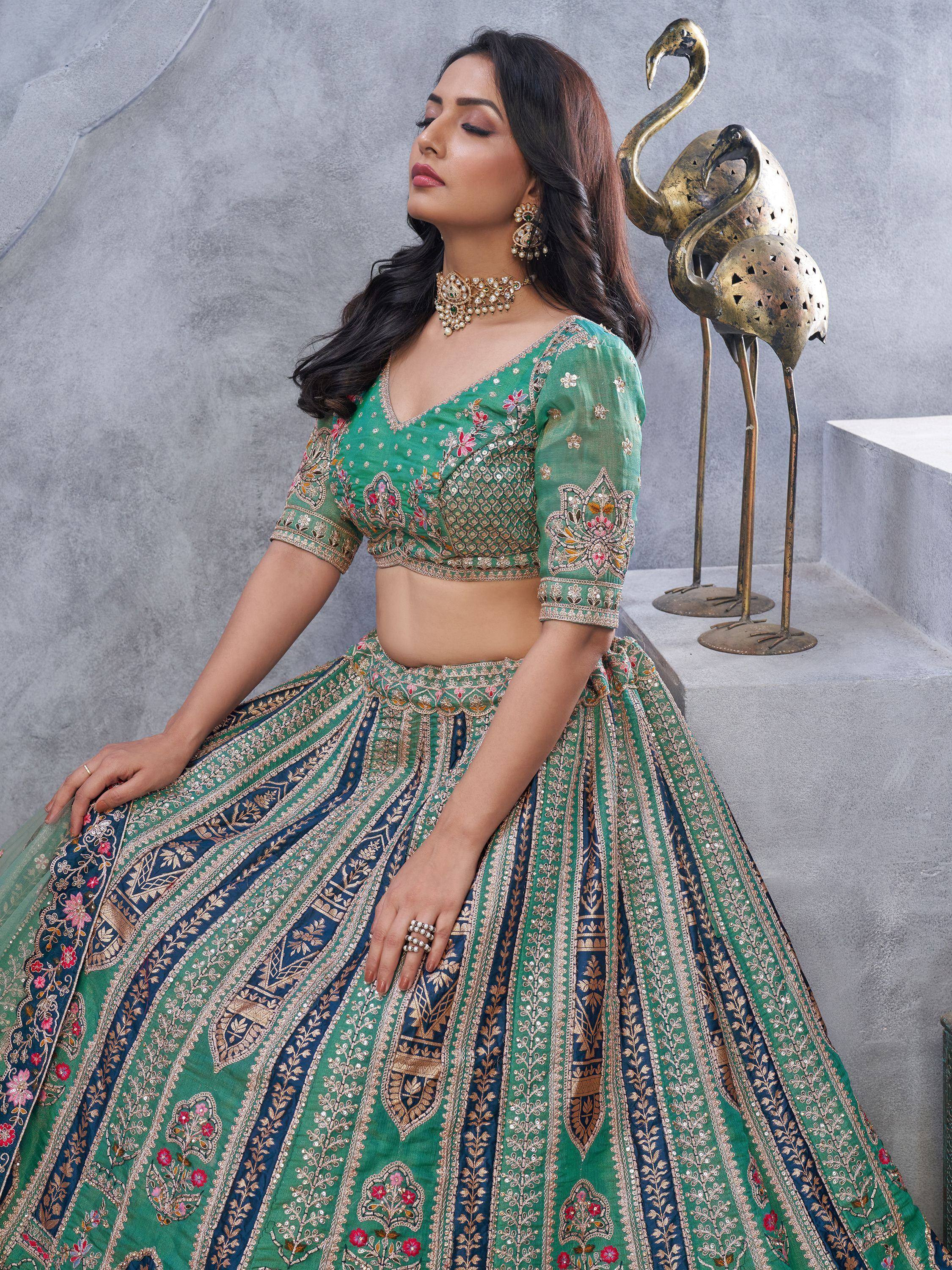 Green and blue embroidered lehenga choli with floral motifs and gold detailing, perfect for Indian ethnic wear.