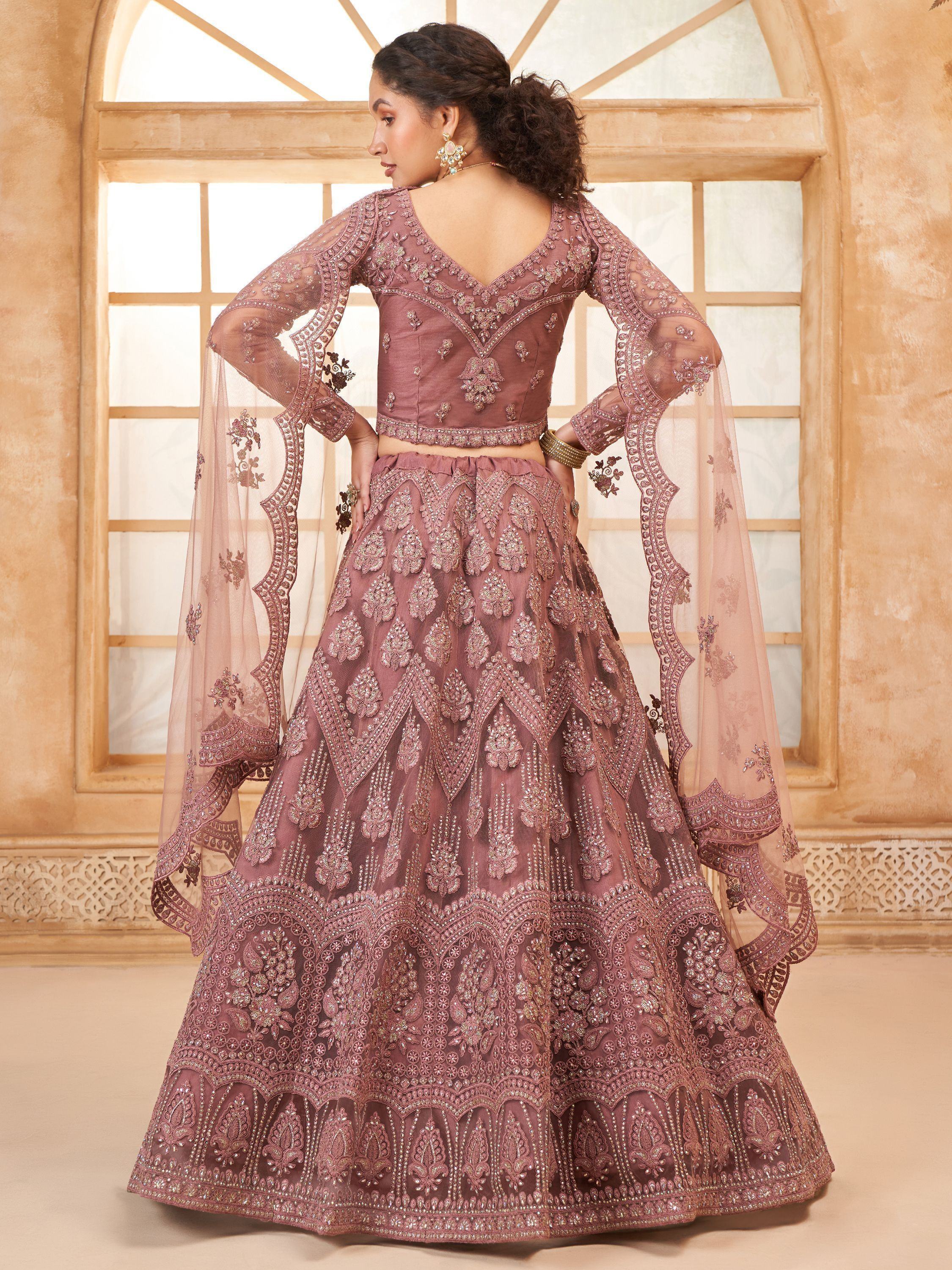 Elegant mauve lehenga choli with intricate embroidery and sheer bell sleeves, perfect for Indian weddings or festive occasions.