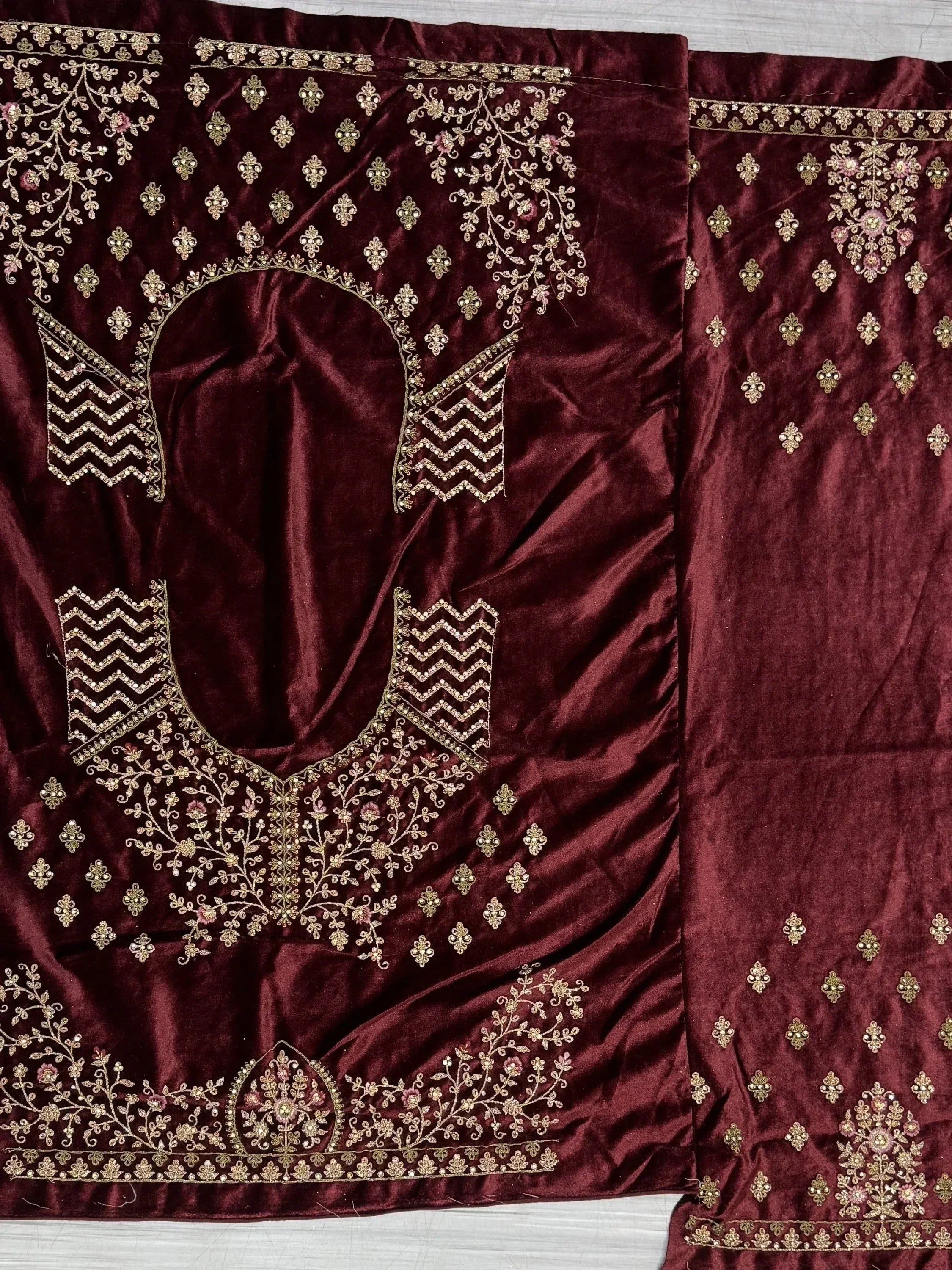 Burgundy velvet ethnic wear with gold floral embroidery and mirror work, perfect for festive occasions.
