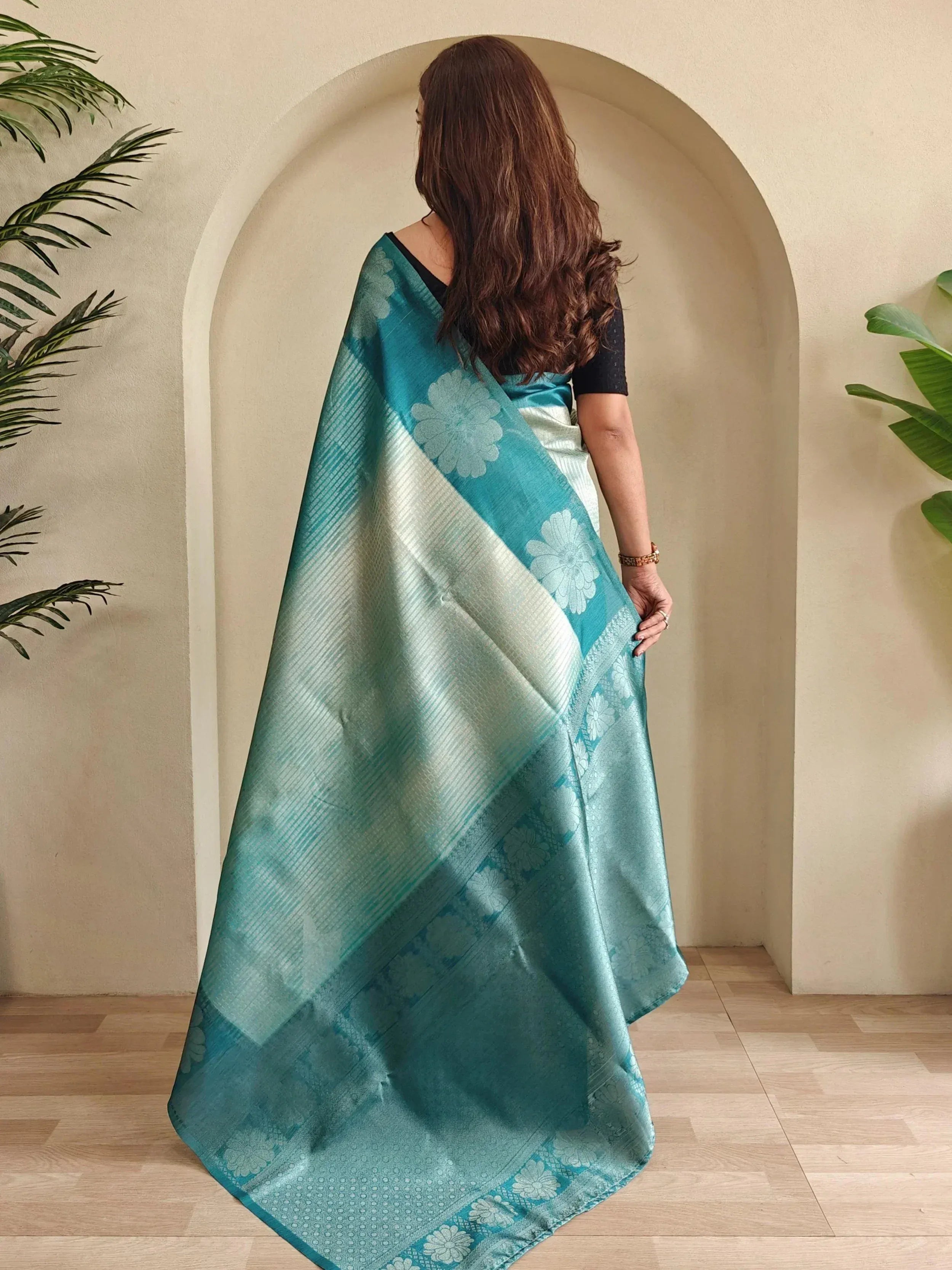 Teal and silver floral saree with elegant drape, perfect for Indian ethnic wear occasions.