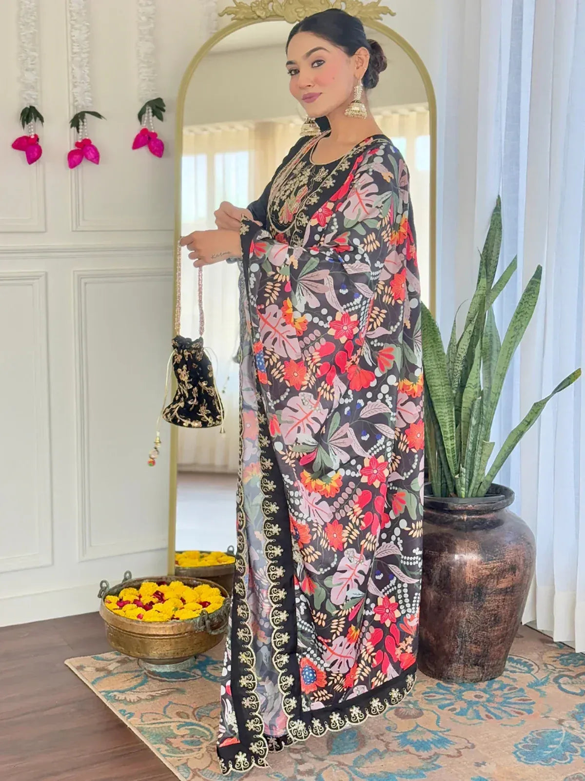 Floral printed ethnic gown with gold embroidery, paired with a matching potli bag, perfect for Indian festivities.