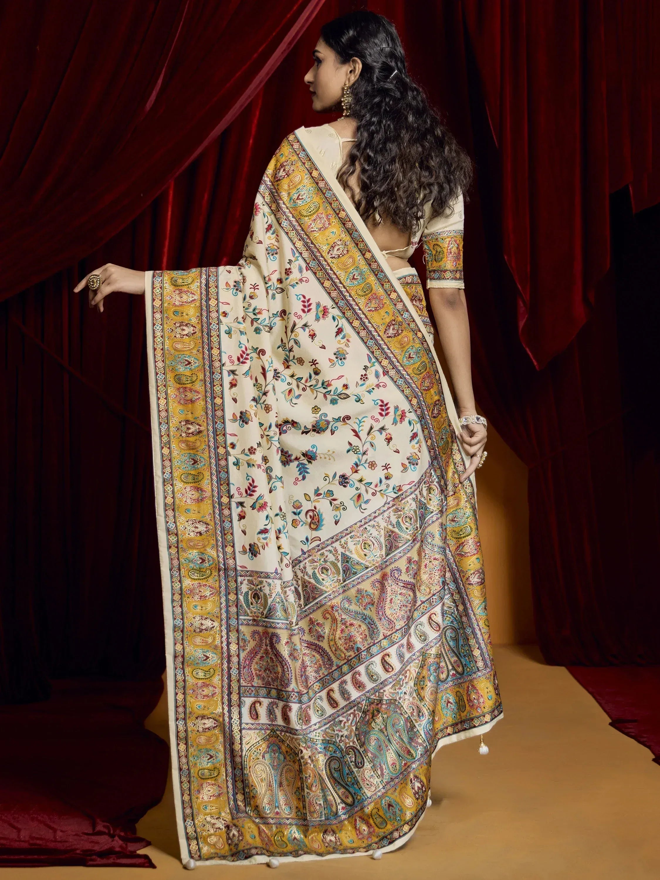 Woman in cream saree with colorful paisley and floral print, ethnic Indian wear