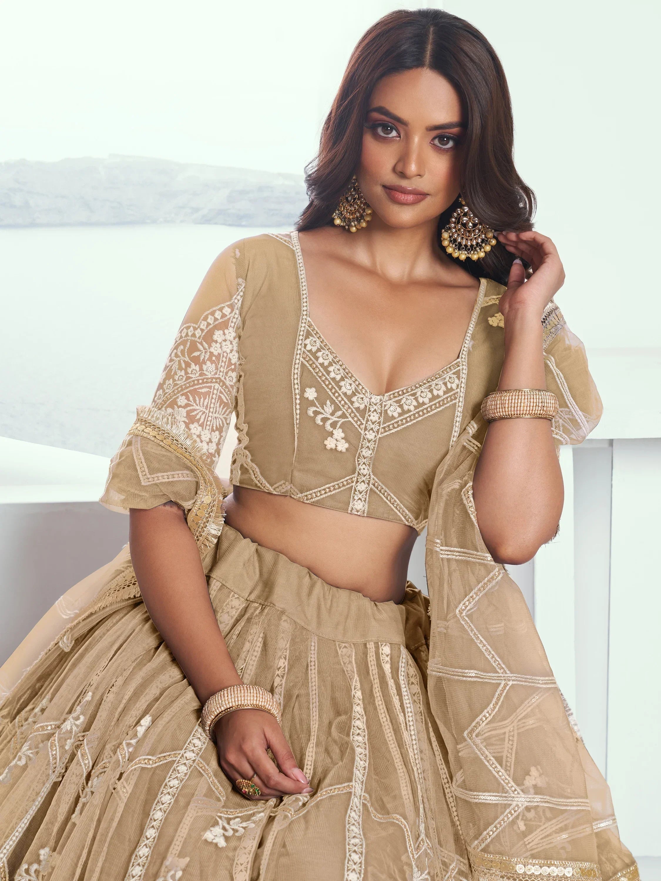 Beige embroidered lehenga choli with sheer sleeves, perfect for Indian ethnic wear occasions