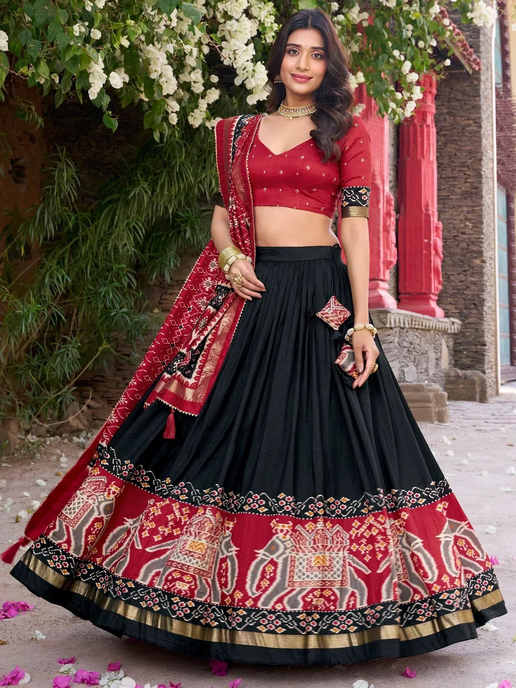 Red and black ethnic lehenga choli with elephant print, perfect for Indian weddings and festive occasions.