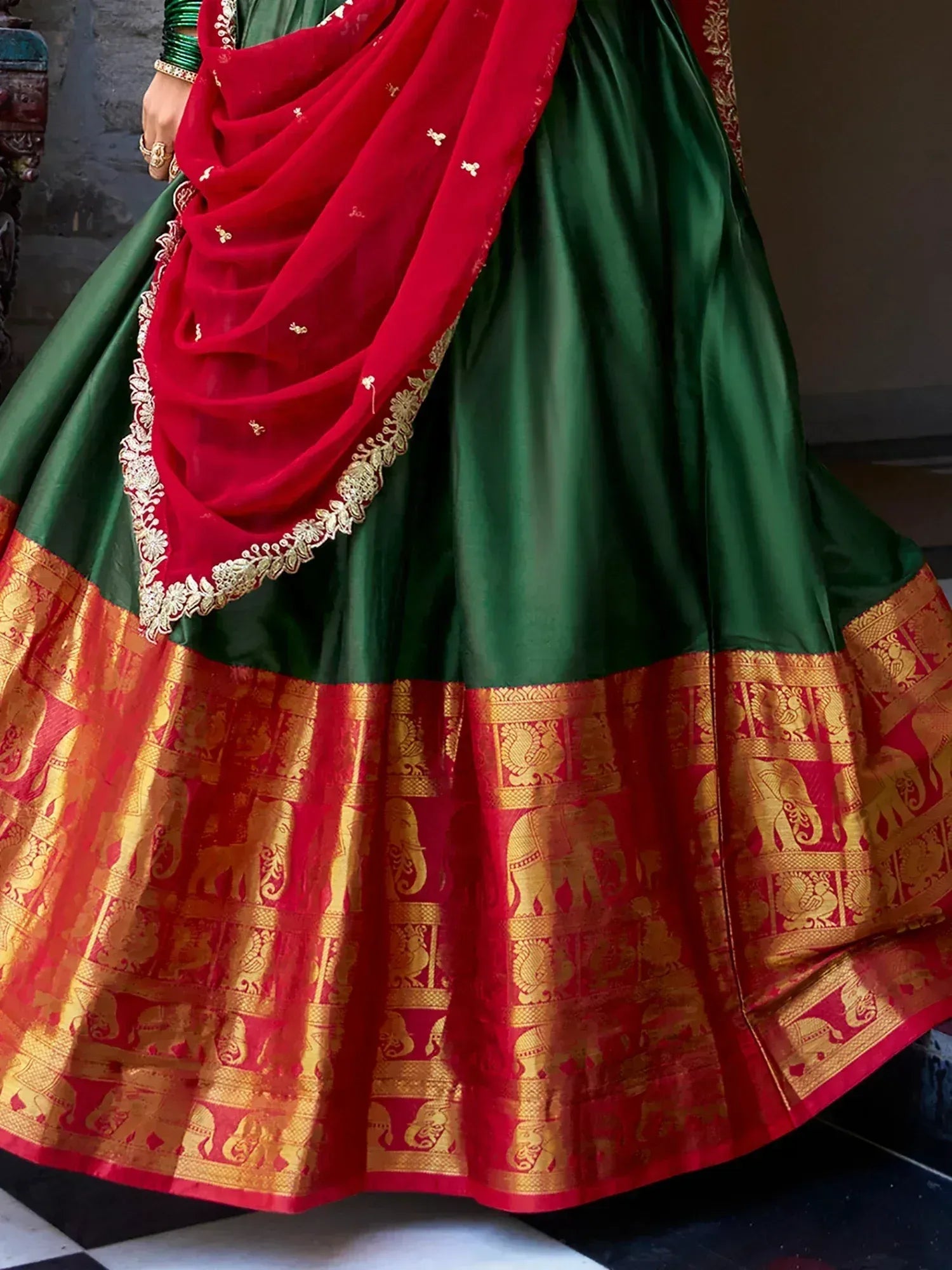 Green and red Indian lehenga with gold elephant border and embroidered dupatta