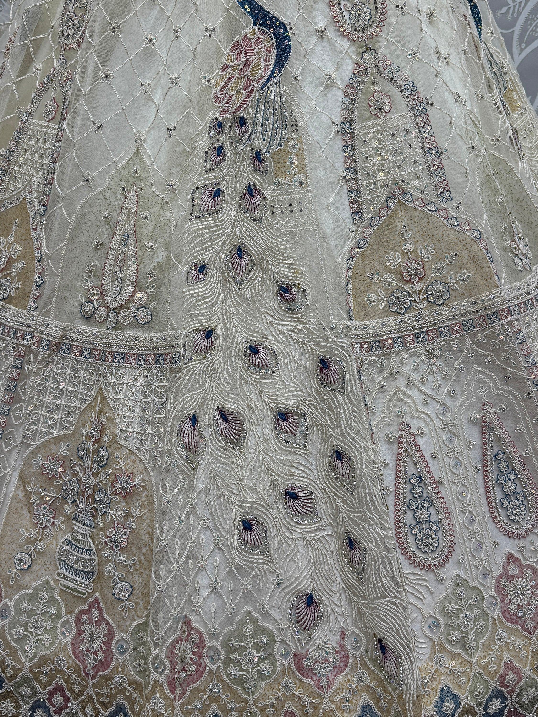 Elegant white lehenga with intricate peacock embroidery and floral sequin details, perfect for Indian ethnic wear.