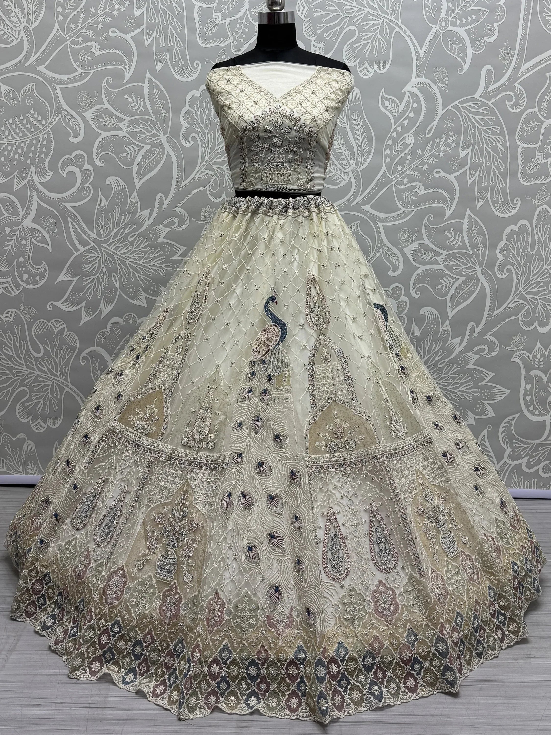 Elegant ivory lehenga choli with peacock embroidery, perfect for Indian weddings and festive occasions.