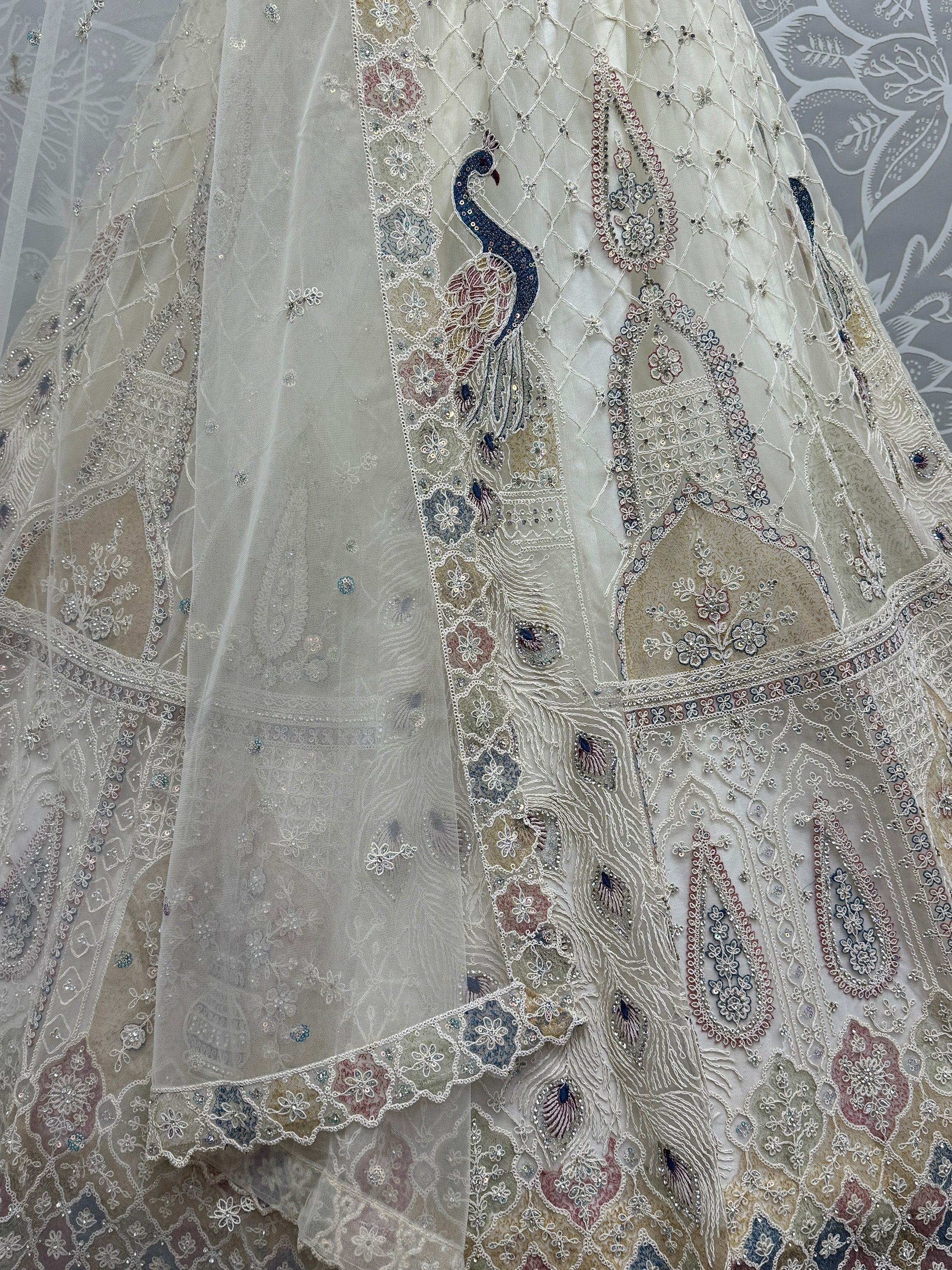 Elegant white lehenga with peacock embroidery and floral motifs, perfect for Indian weddings and festive occasions.