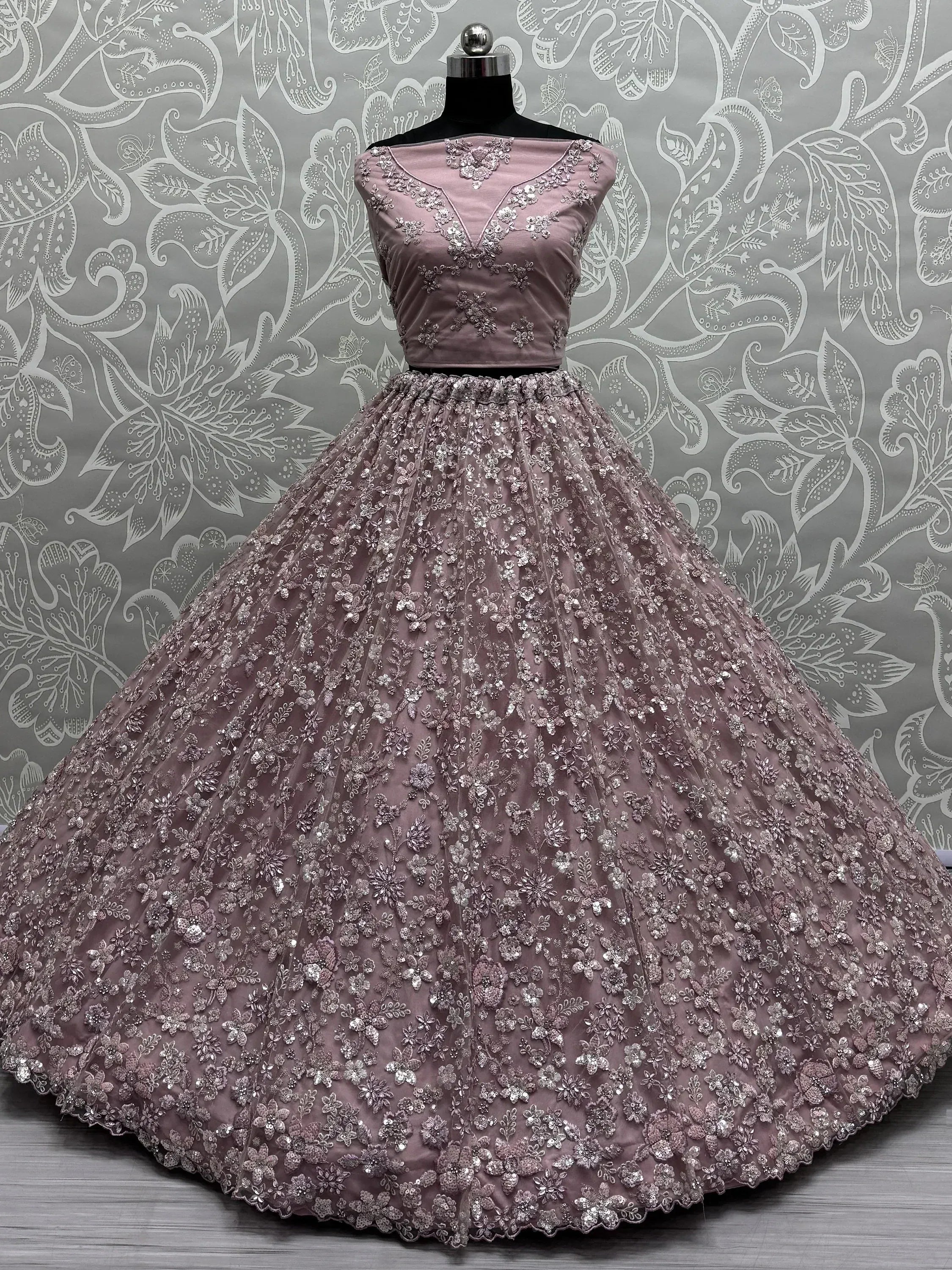 Dusty pink designer lehenga choli with heavy floral embroidery and sequins, perfect for weddings and parties.