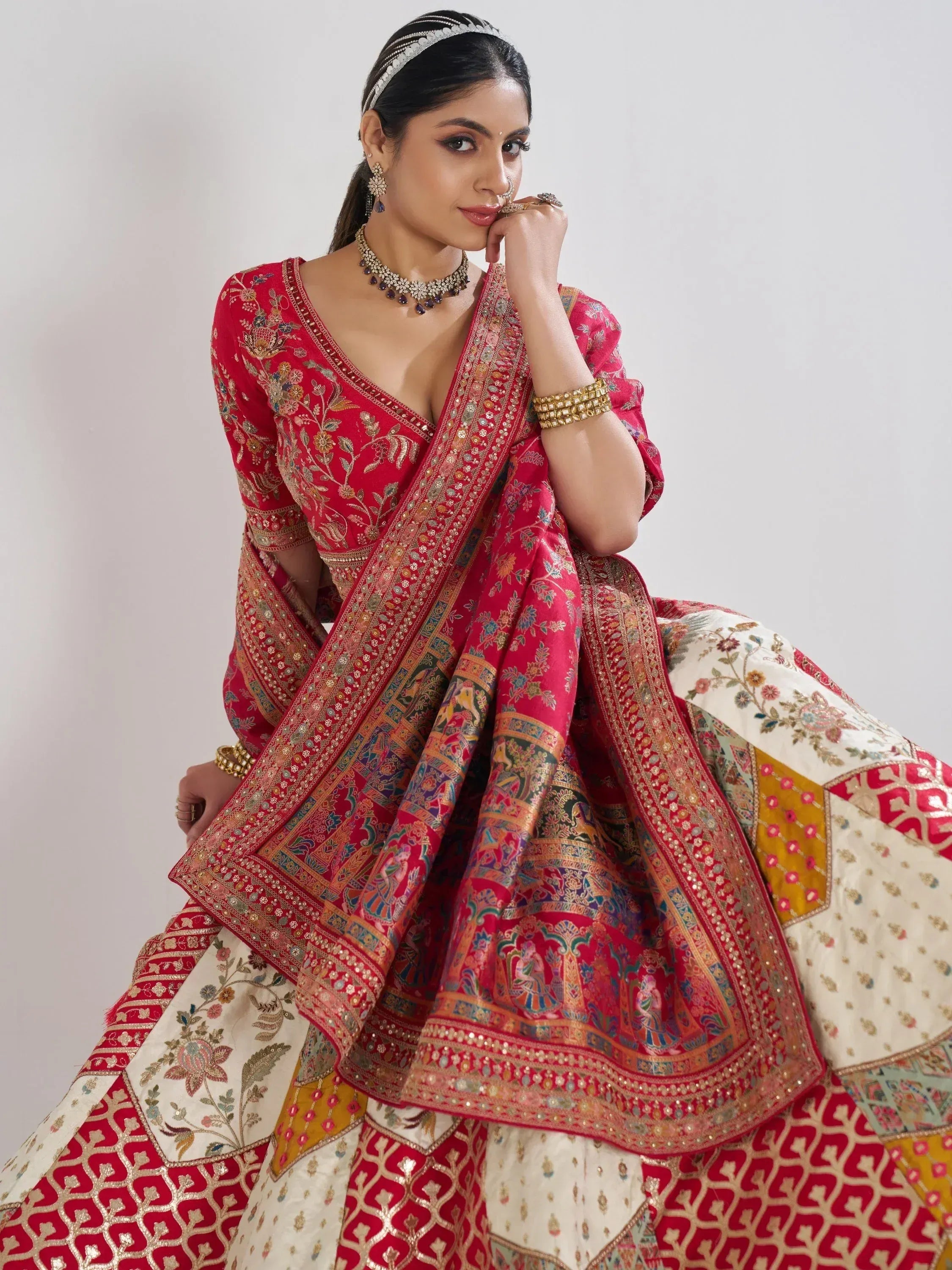 Red and cream embroidered lehenga choli with floral and patchwork design, perfect for Indian weddings and festivals