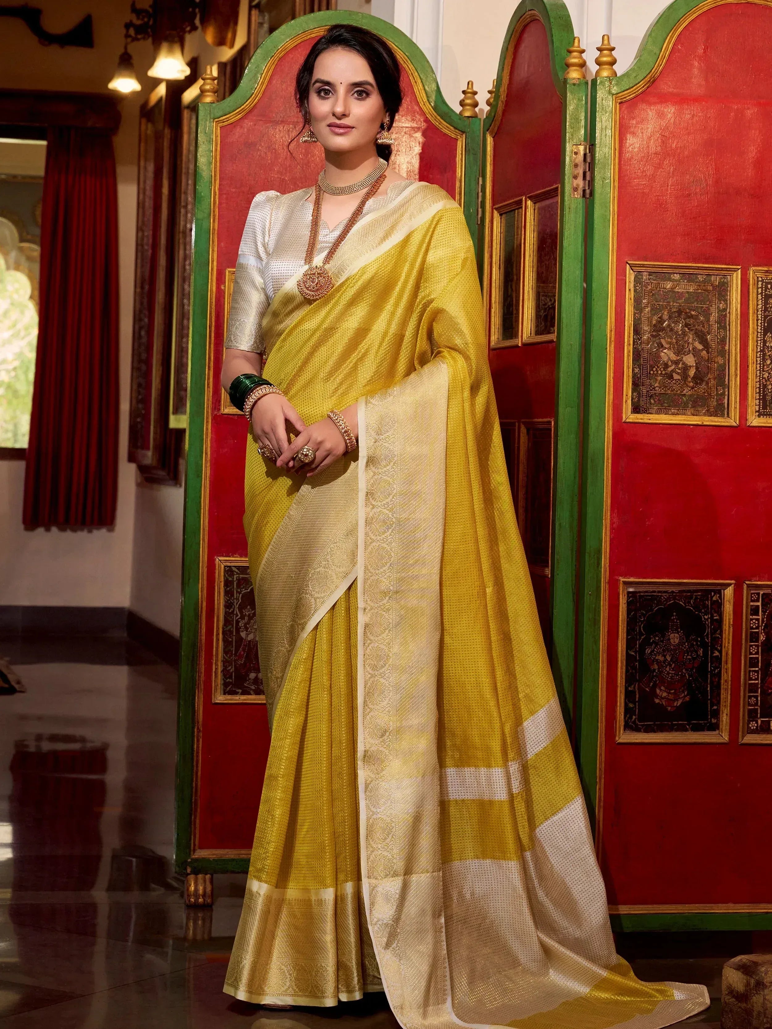 Yellow and white ethnic saree with gold embroidery, paired with designer blouse and traditional jewelry
