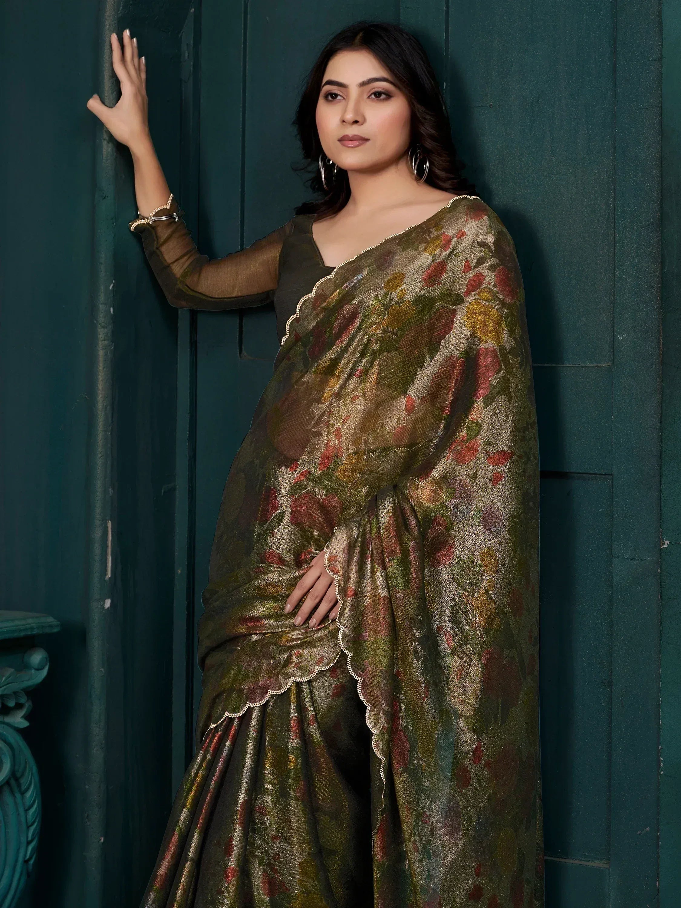 Woman in olive green floral saree with scalloped border, elegant Indian ethnic wear for festive occasions.