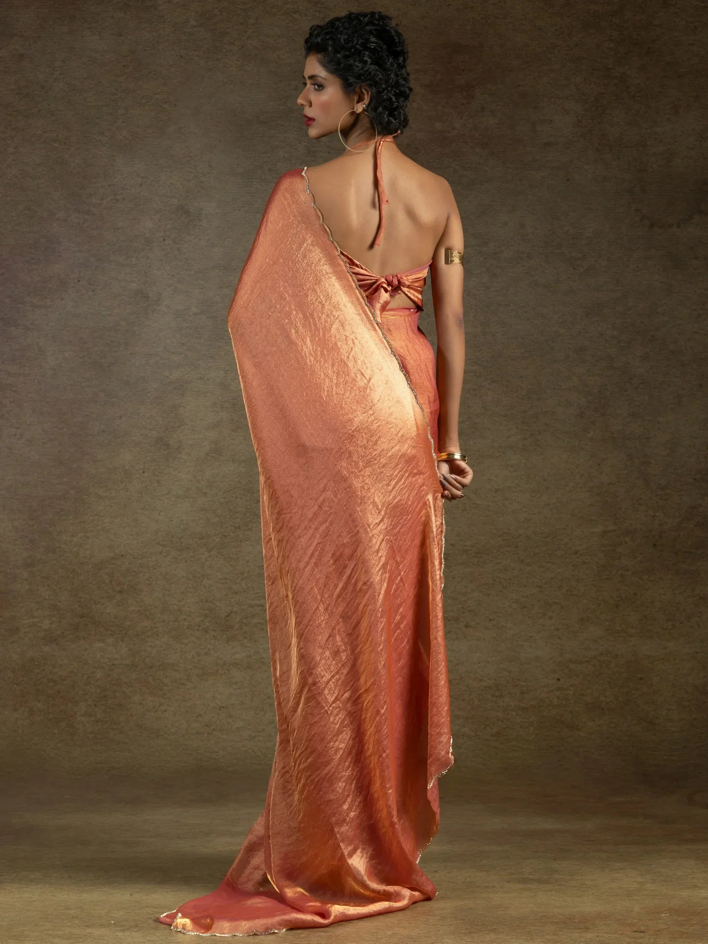 Elegant peach saree with gold trim, backless blouse, perfect for Indian ethnic wear occasions