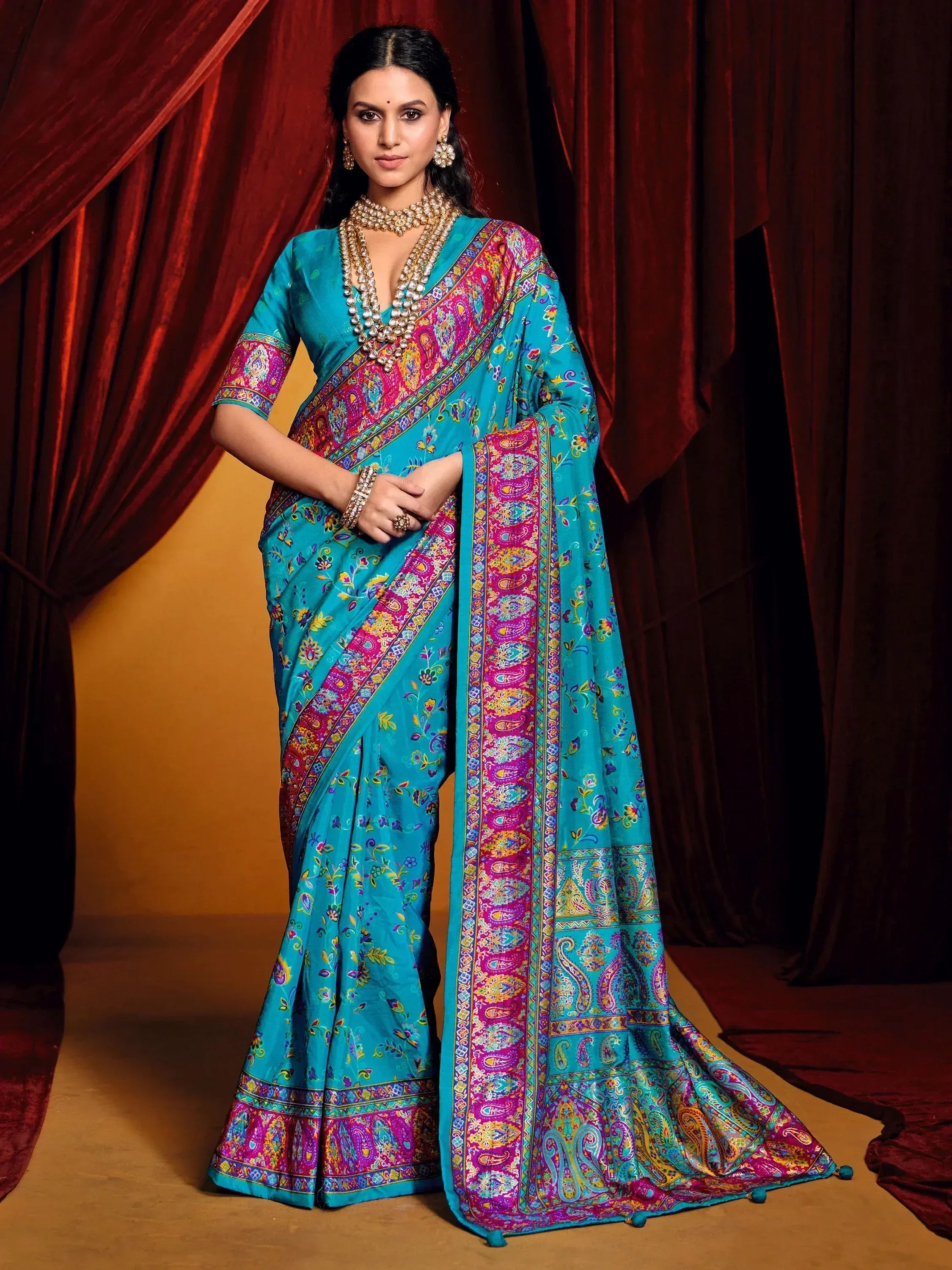 Turquoise saree with vibrant paisley print, perfect for Indian ethnic wear and festive occasions.