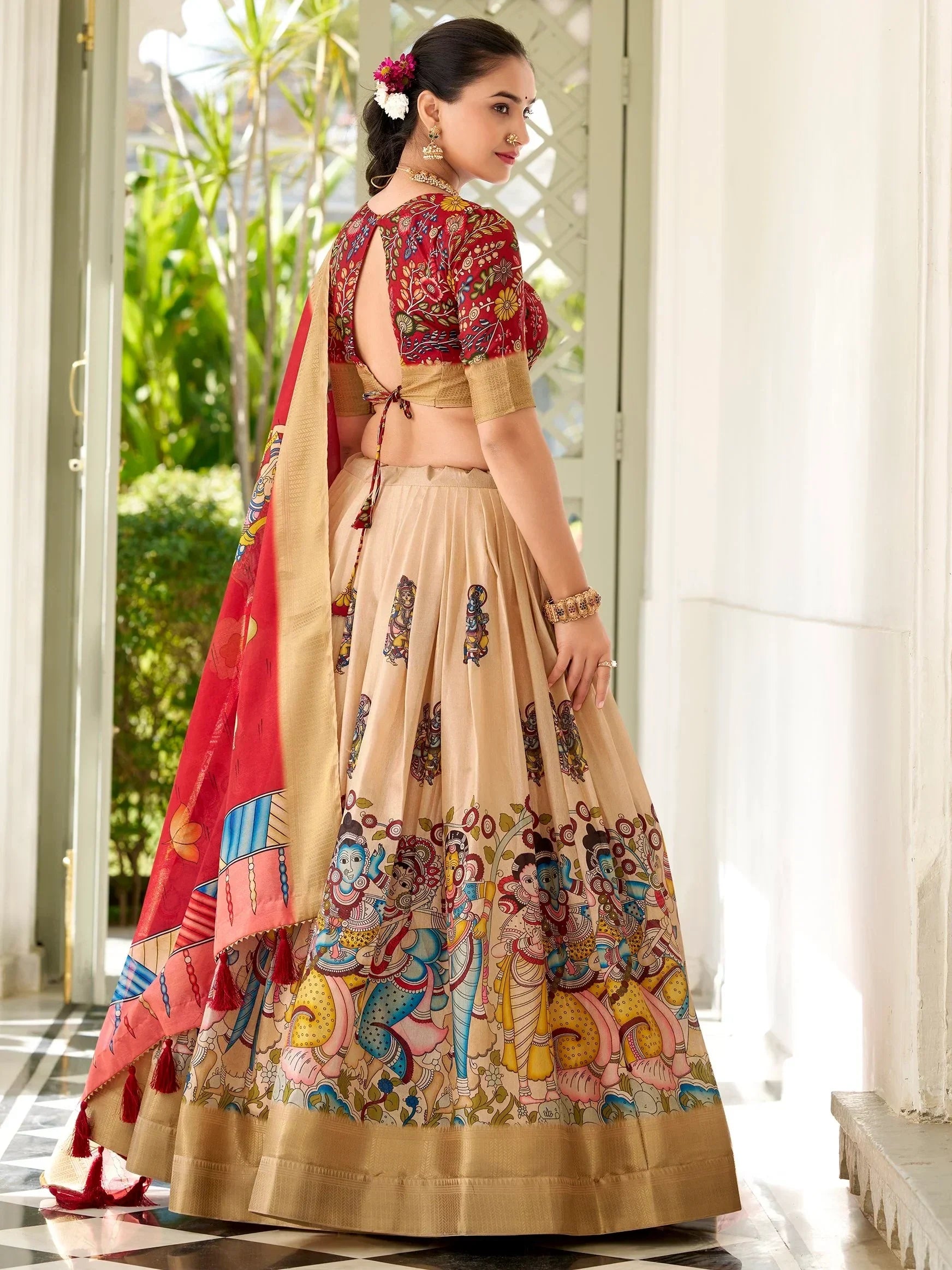 Woman in designer lehenga choli with floral and deity prints, perfect for Indian ethnic wear occasions