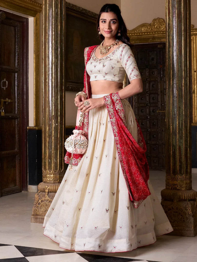Elegant ivory lehenga choli with red dupatta, perfect for Indian weddings and festive occasions.