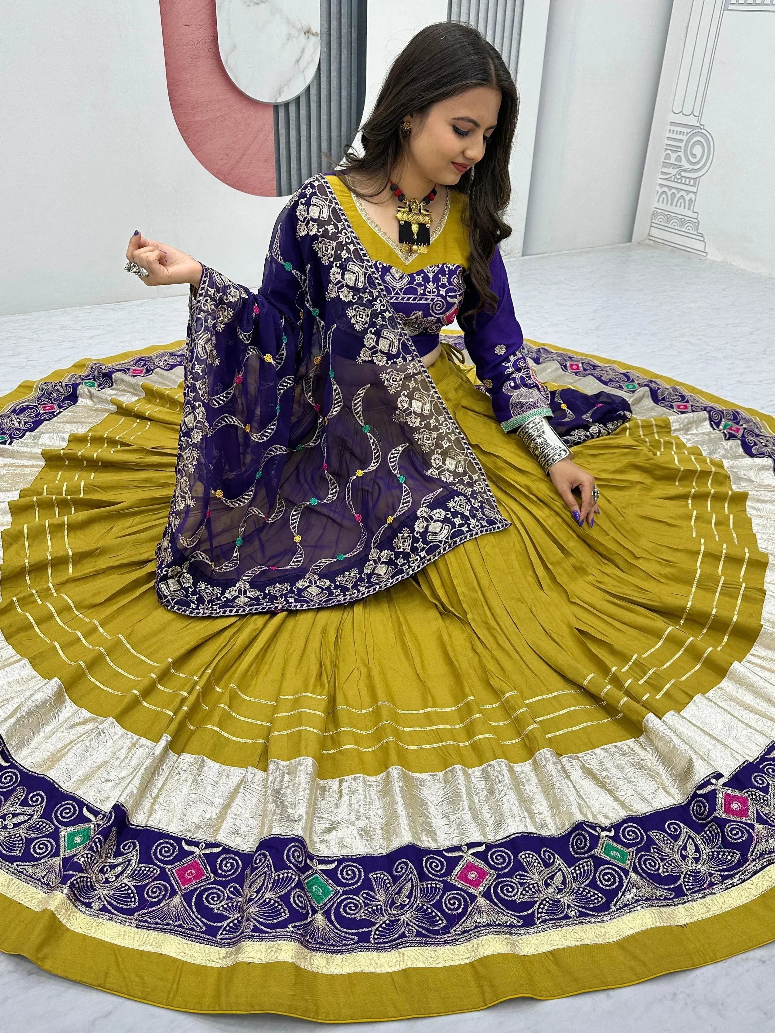 Woman in purple and mustard yellow embroidered lehenga choli with floral dupatta, perfect for Indian ethnic occasions