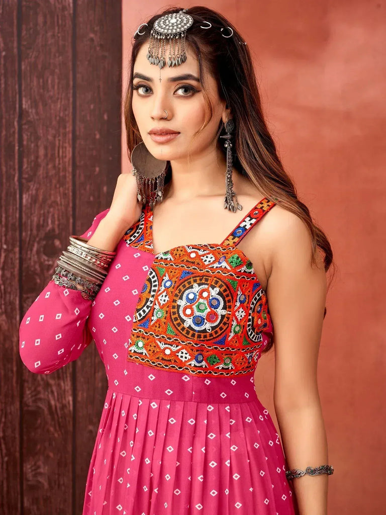Pink ethnic gown with colorful embroidery and traditional jewelry