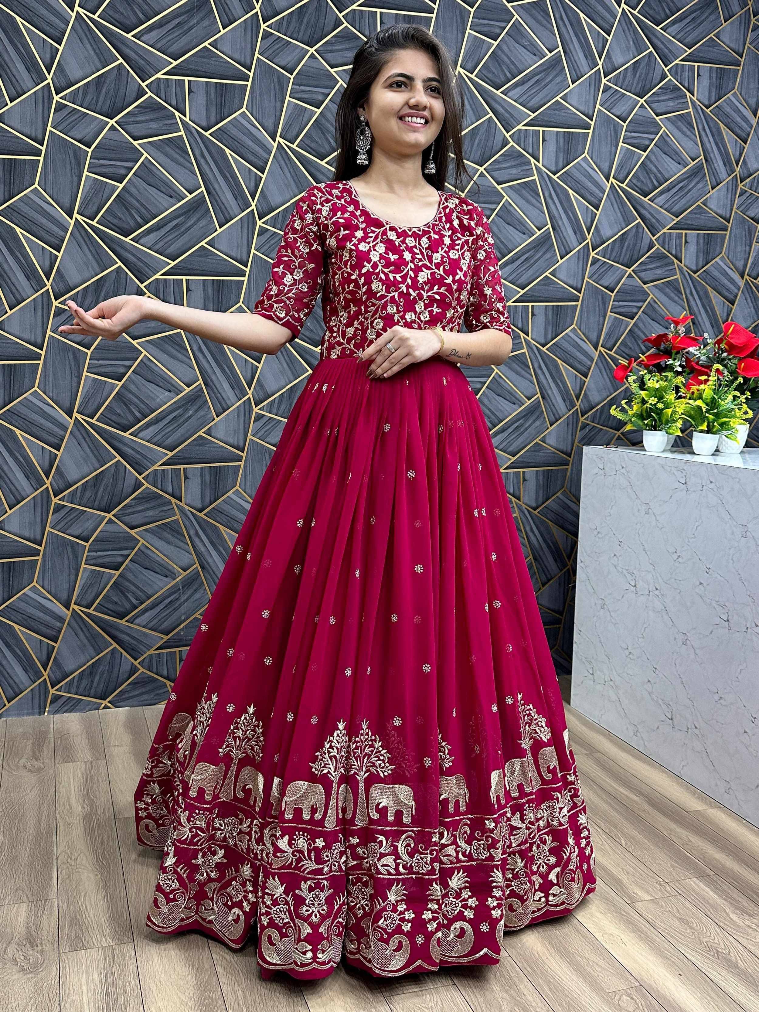Woman in maroon ethnic gown with gold elephant and floral embroidery, perfect for Indian celebrations