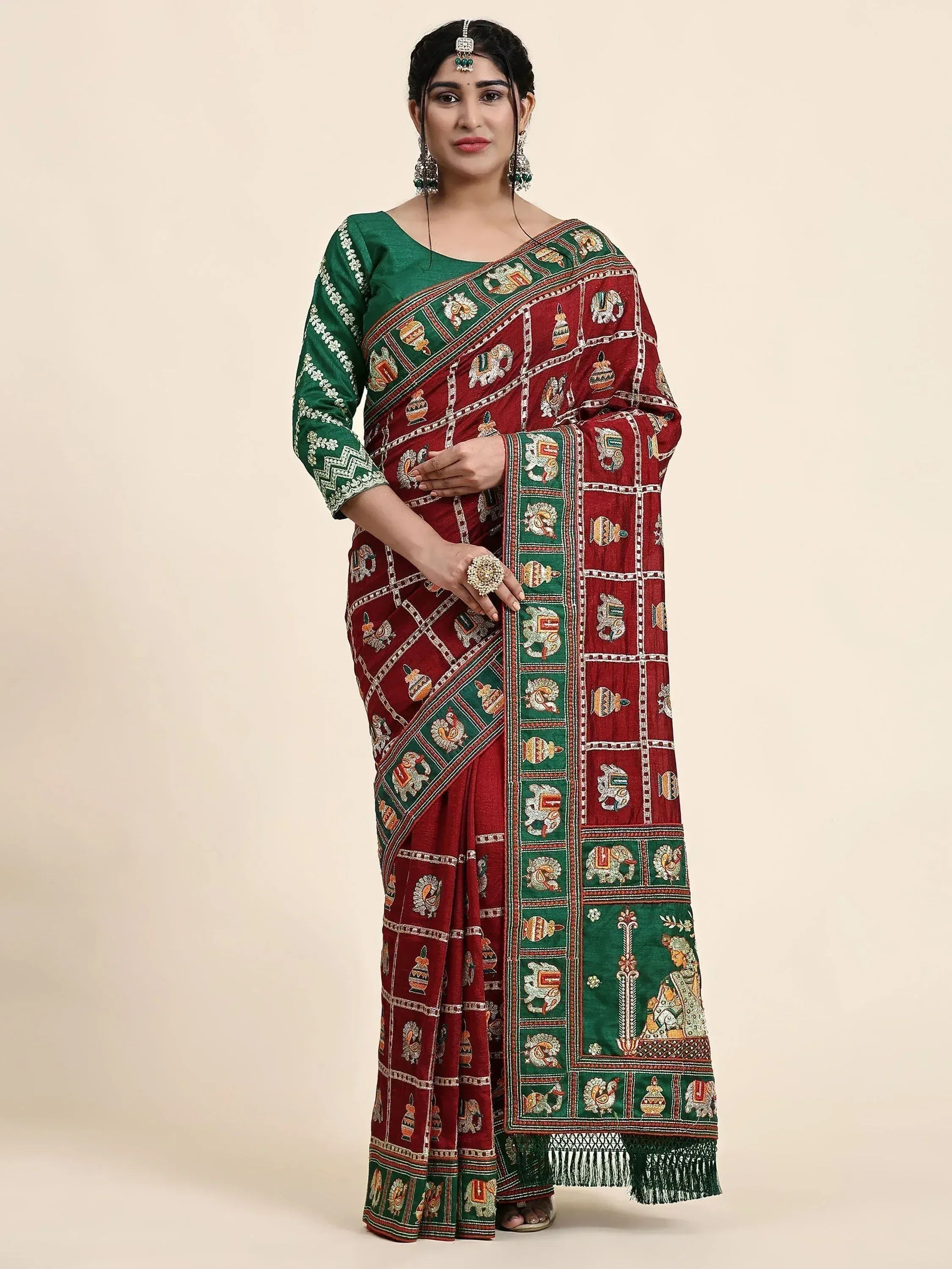 Woman in maroon and green embroidered saree with elephant motifs, traditional Indian ethnic wear