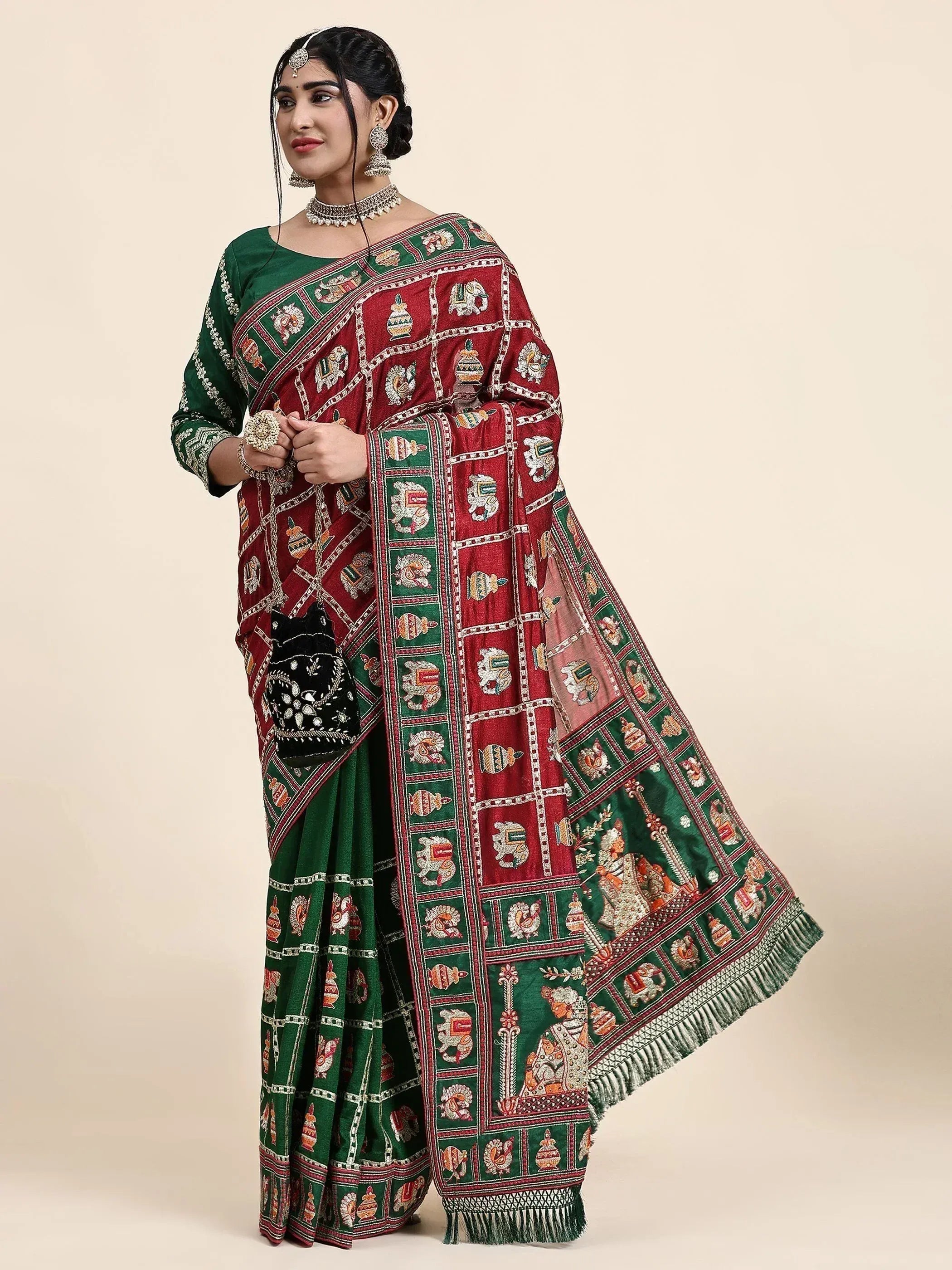 Woman in green and red embroidered saree with elephant motifs, traditional Indian ethnic wear