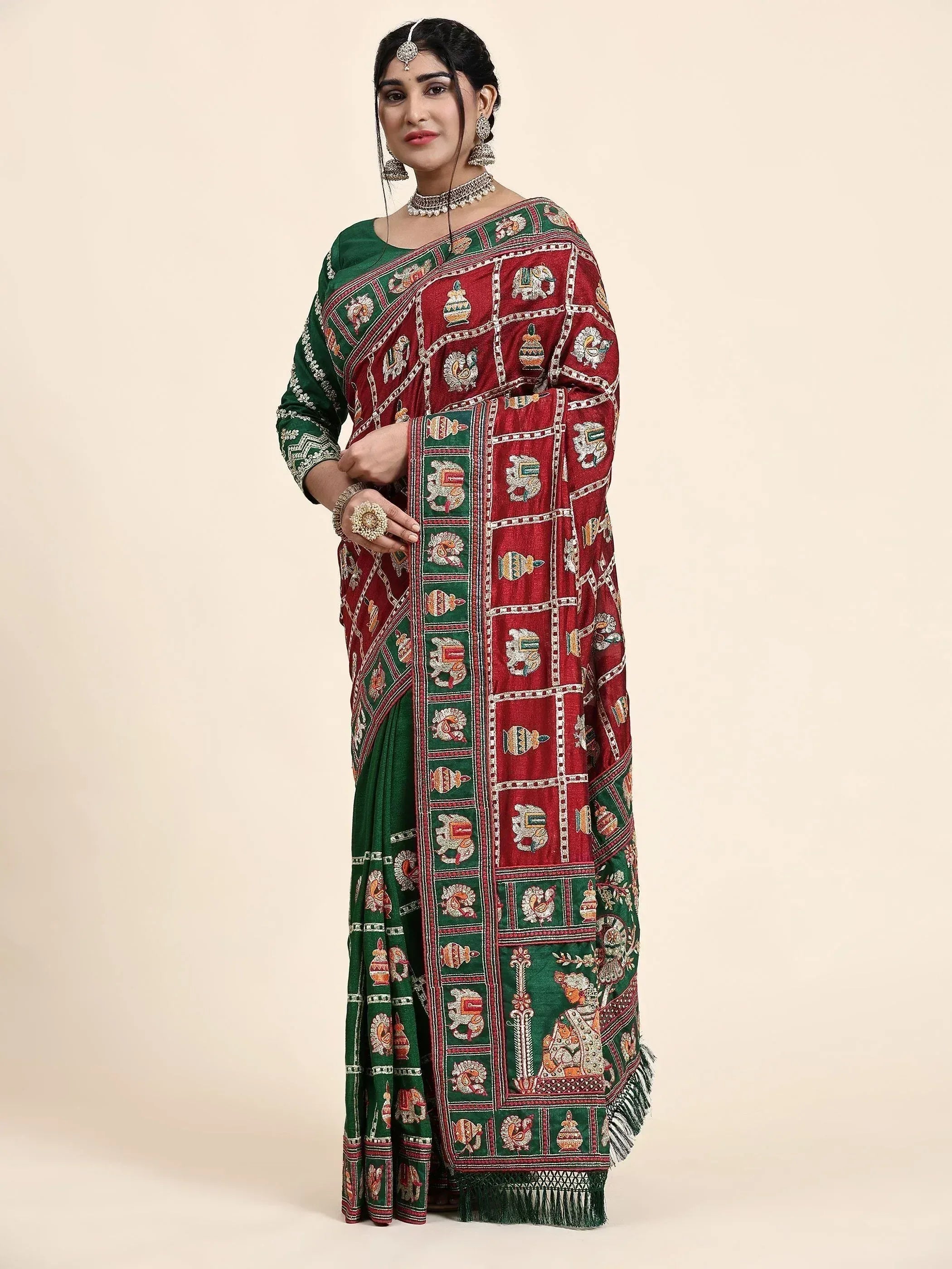 Woman in red and green embroidered saree with elephant motifs, traditional Indian ethnic wear