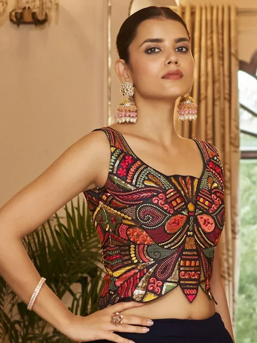 Embroidered ethnic crop top with vibrant patterns, paired with statement jhumka earrings for festive wear.