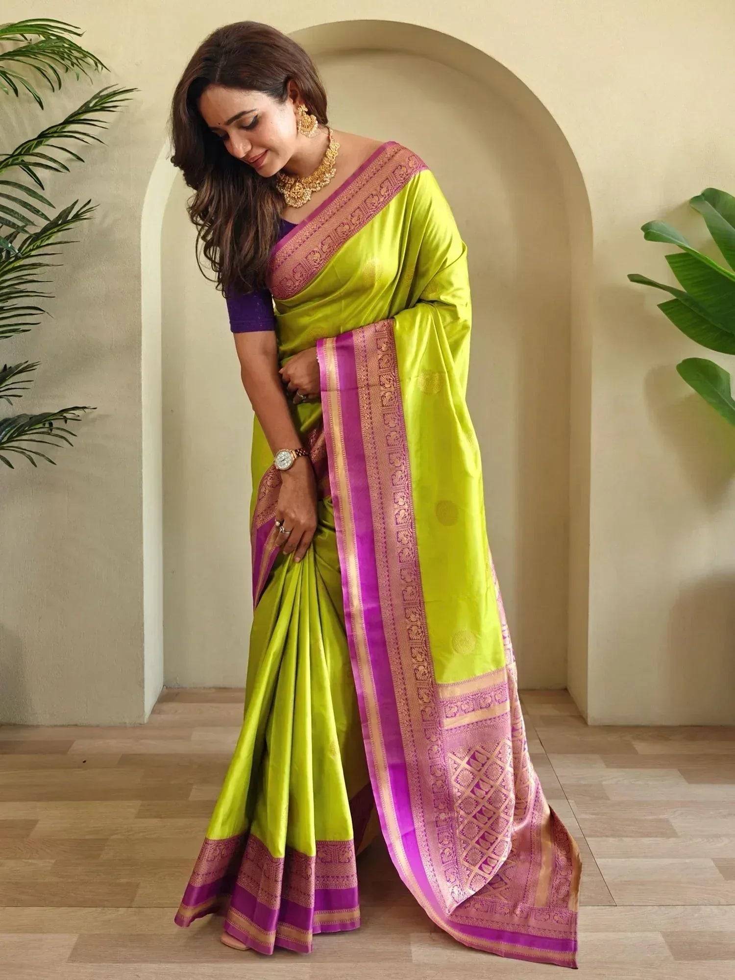 Vibrant green silk saree with purple and gold border, styled with traditional jewelry for ethnic wear
