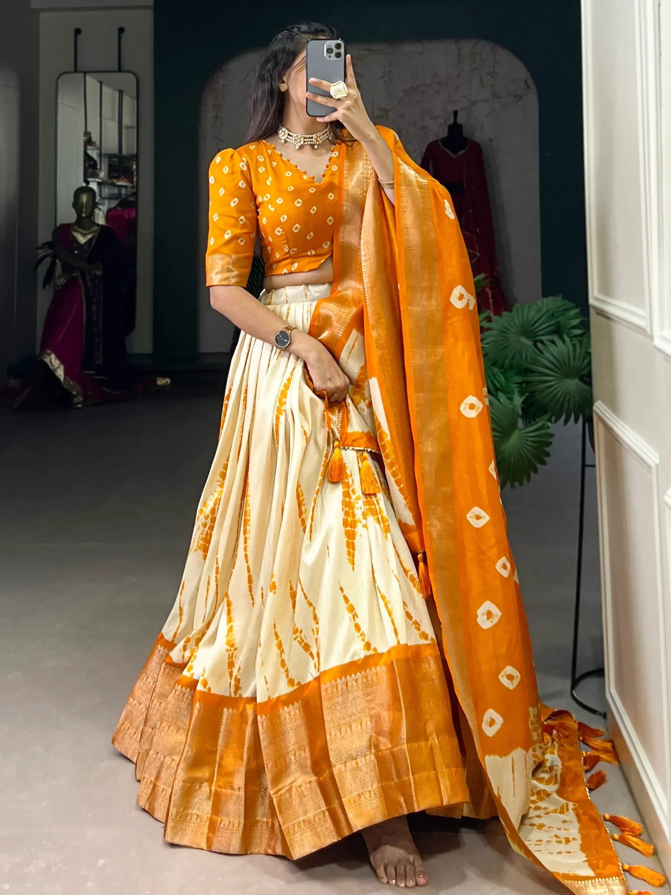 Orange and cream tie-dye lehenga choli with matching dupatta, perfect for Indian ethnic wear occasions.