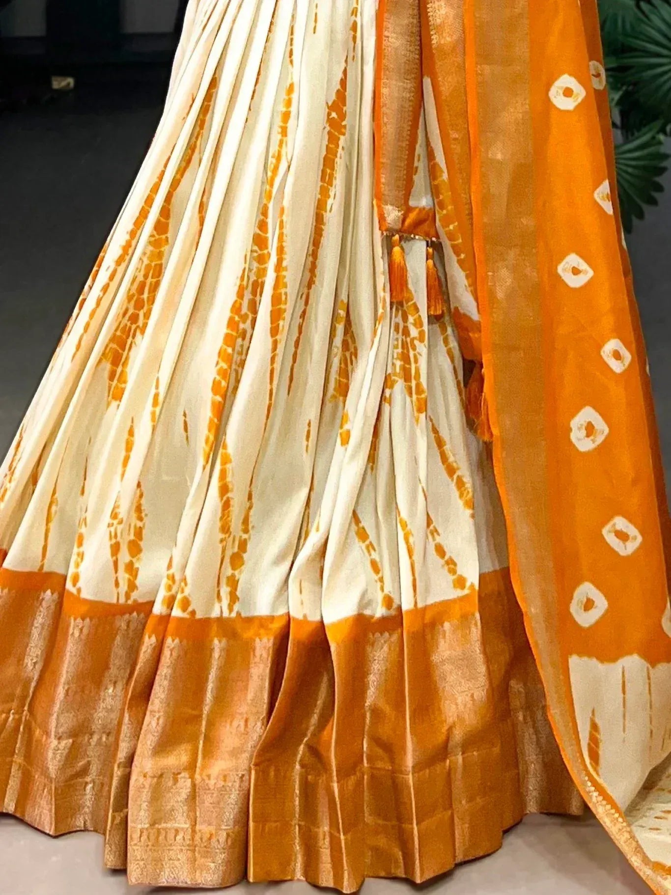 Orange and cream tie-dye lehenga with woven border and matching dupatta, ethnic Indian wear