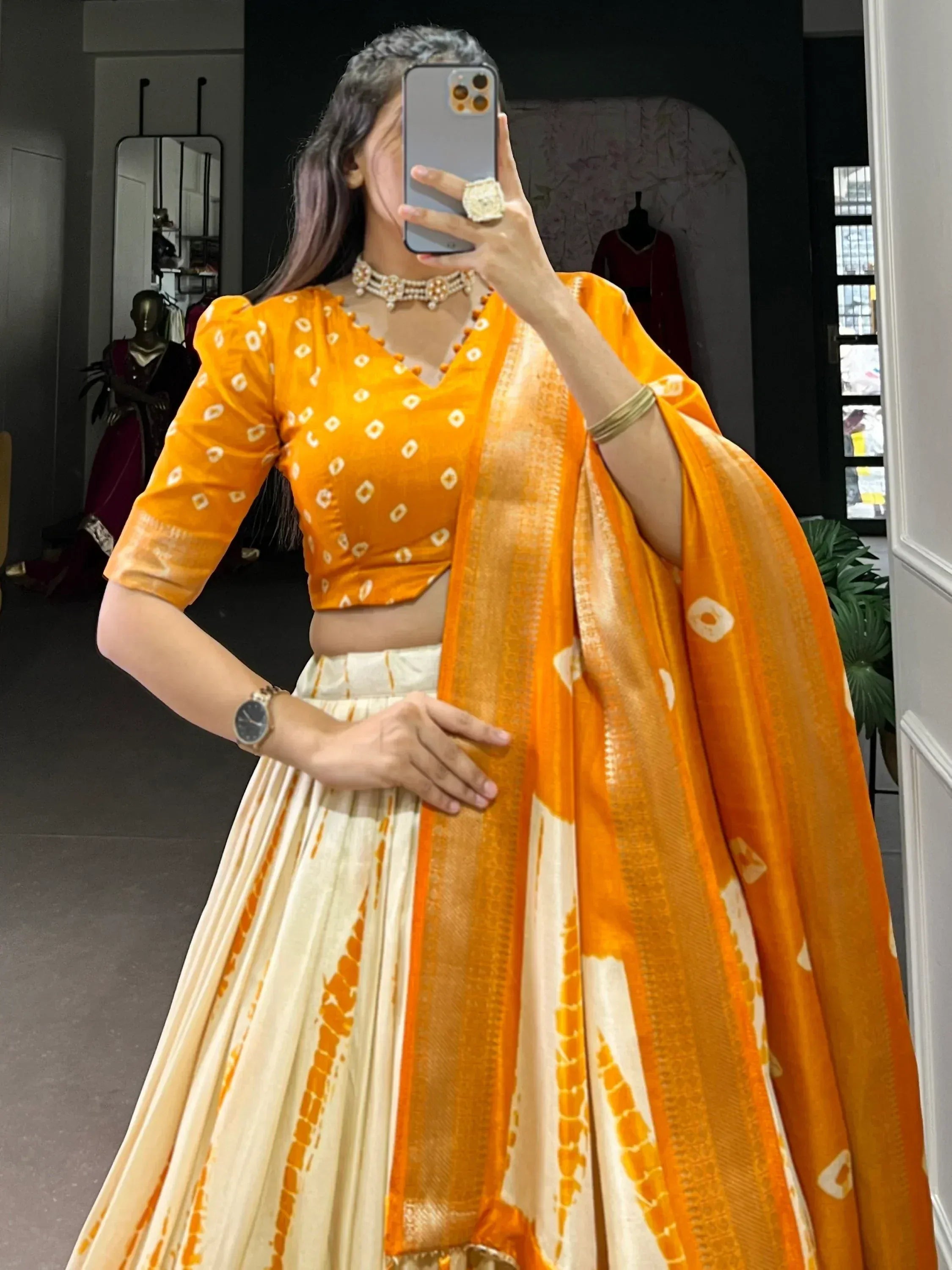 Vibrant orange and cream lehenga choli with bandhani print, perfect for Indian ethnic wear occasions