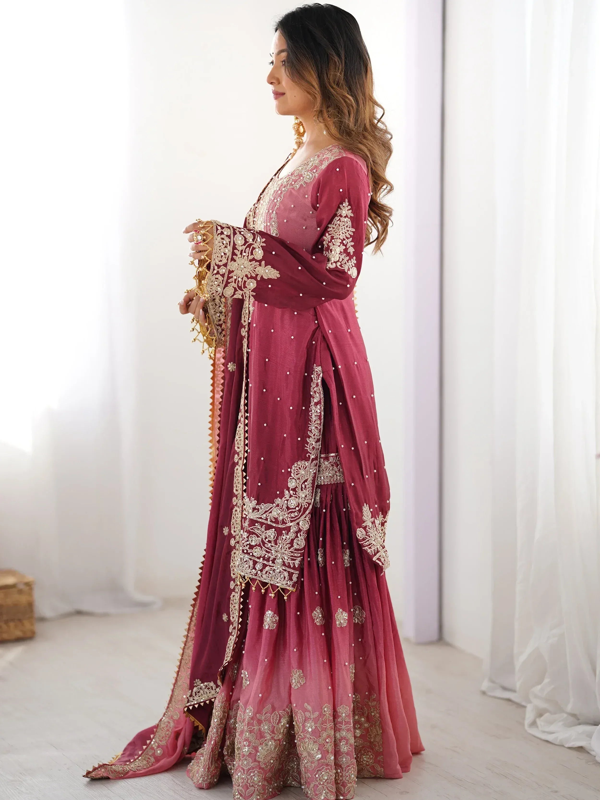 Maroon Indian ethnic gown with gold embroidery and pearl detailing, perfect for weddings or festive occasions.