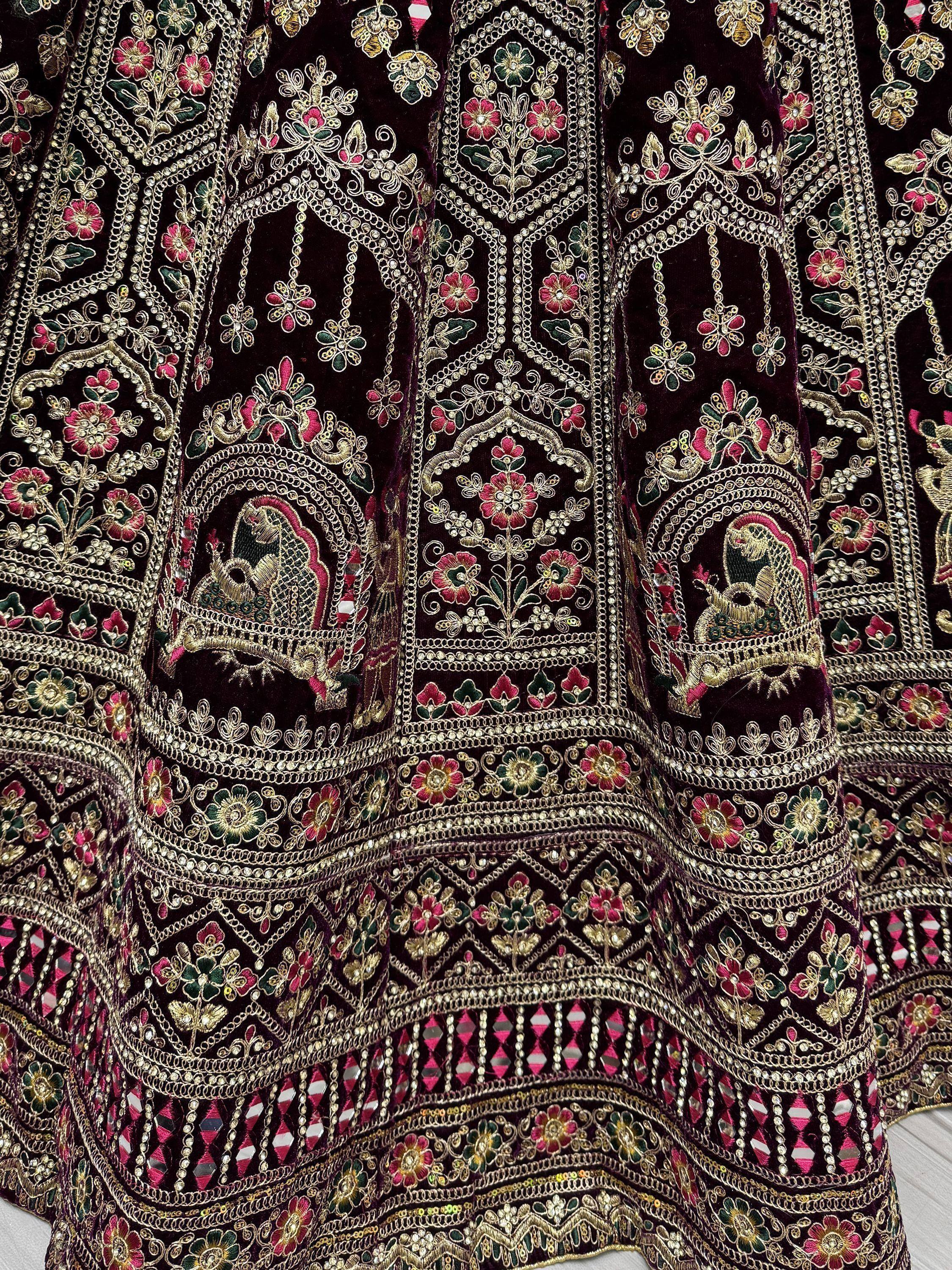 Luxury Indian ethnic wear with intricate floral embroidery, mirror work, and gold detailing on velvet fabric.