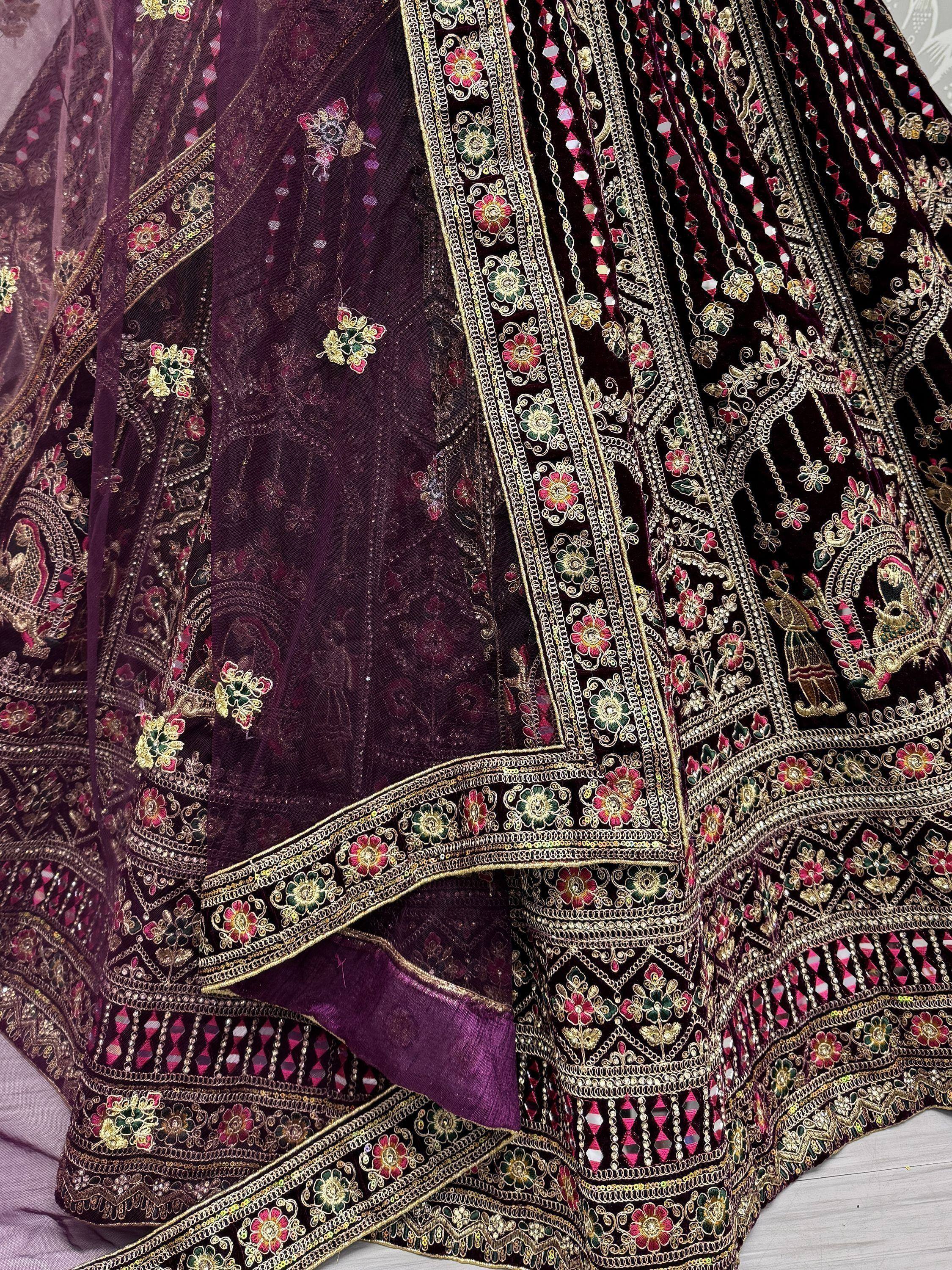 Luxury purple velvet lehenga choli with intricate gold embroidery and floral mirror work, perfect for Indian weddings.