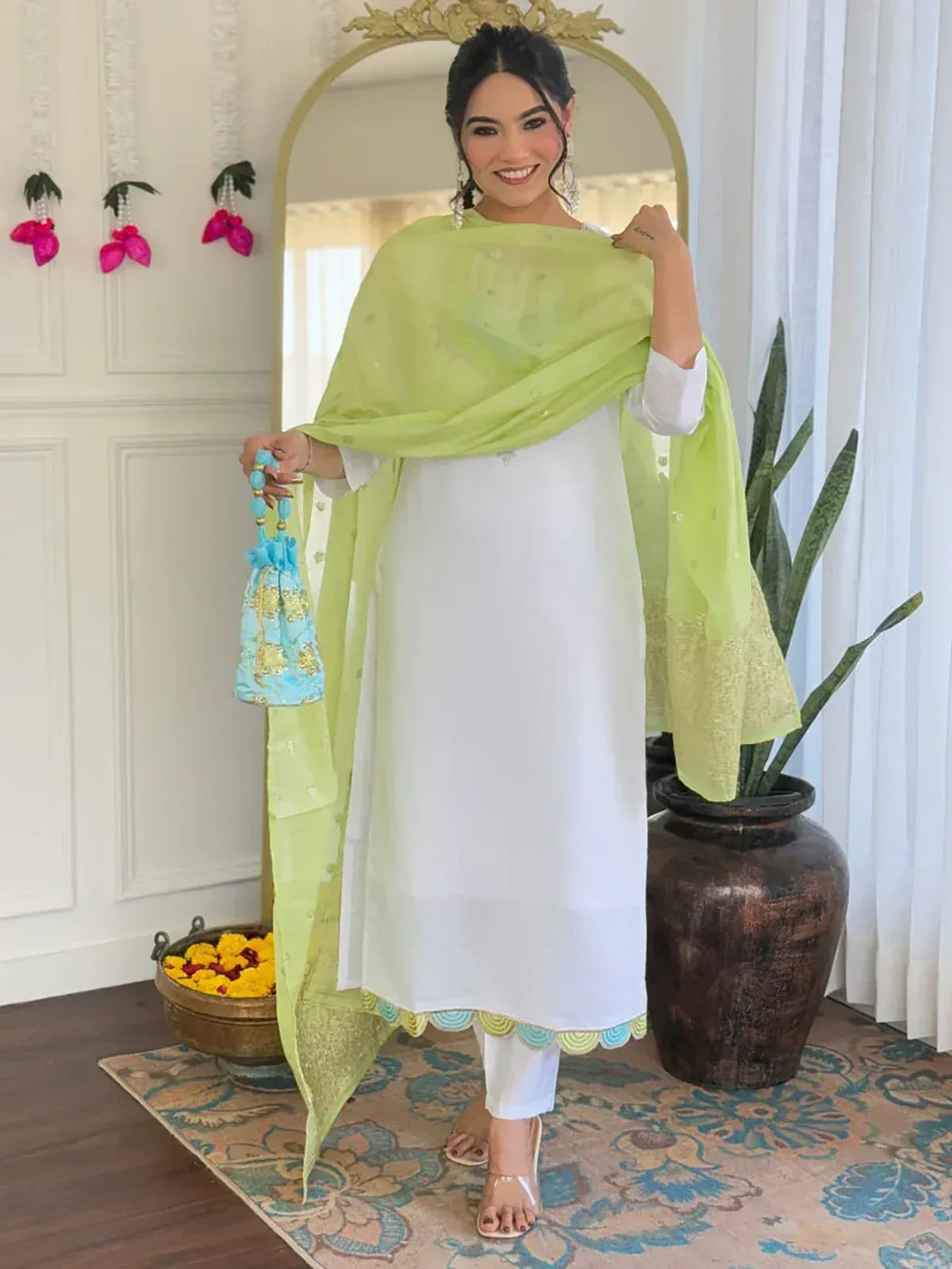 White kurta with lime green dupatta, scalloped hem, paired with white pants and blue potli bag for ethnic wear