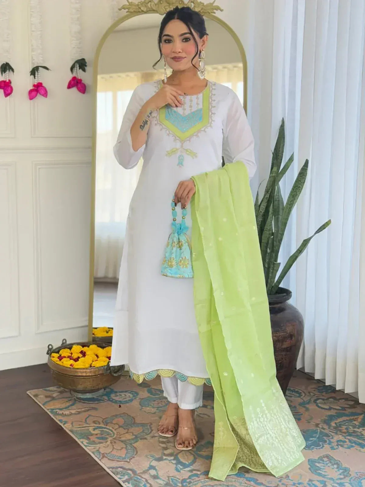 White embroidered kurta with lime green dupatta and matching potli bag, styled for ethnic wear