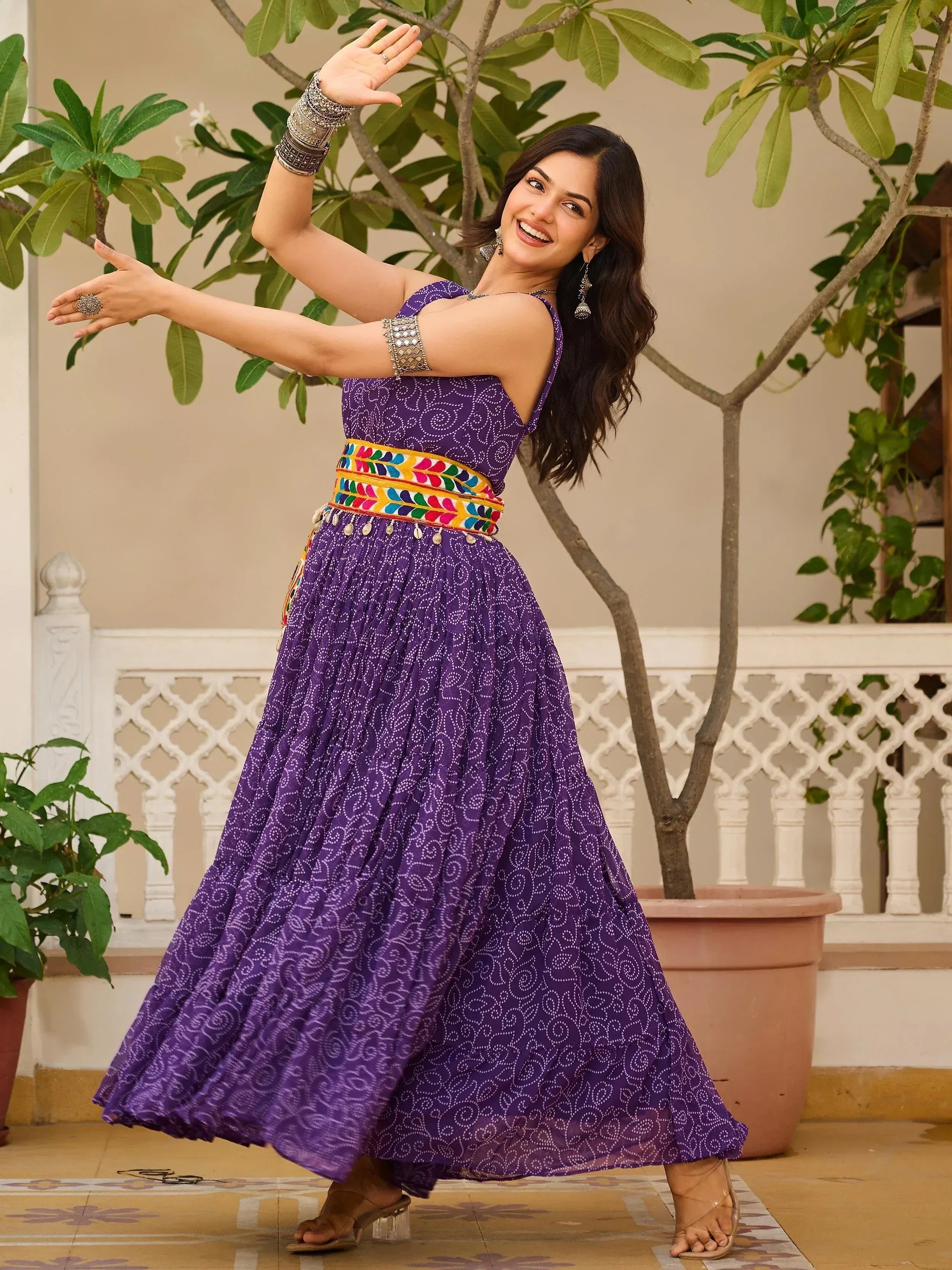 Purple ethnic gown with printed pattern and colorful embroidered belt, perfect for Indian festive occasions