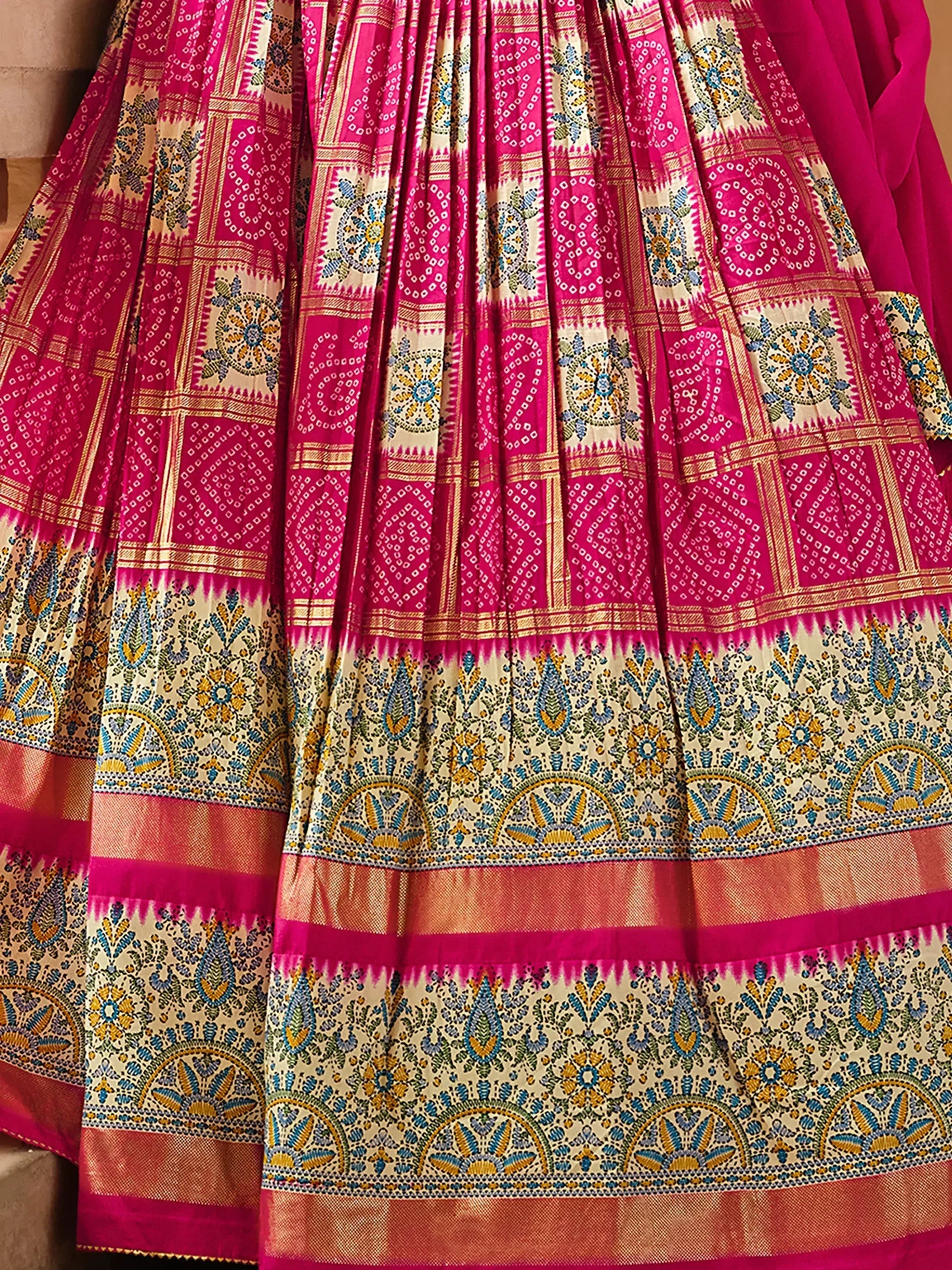 Pink and cream printed lehenga with intricate ethnic patterns and golden borders, perfect for Indian celebrations.