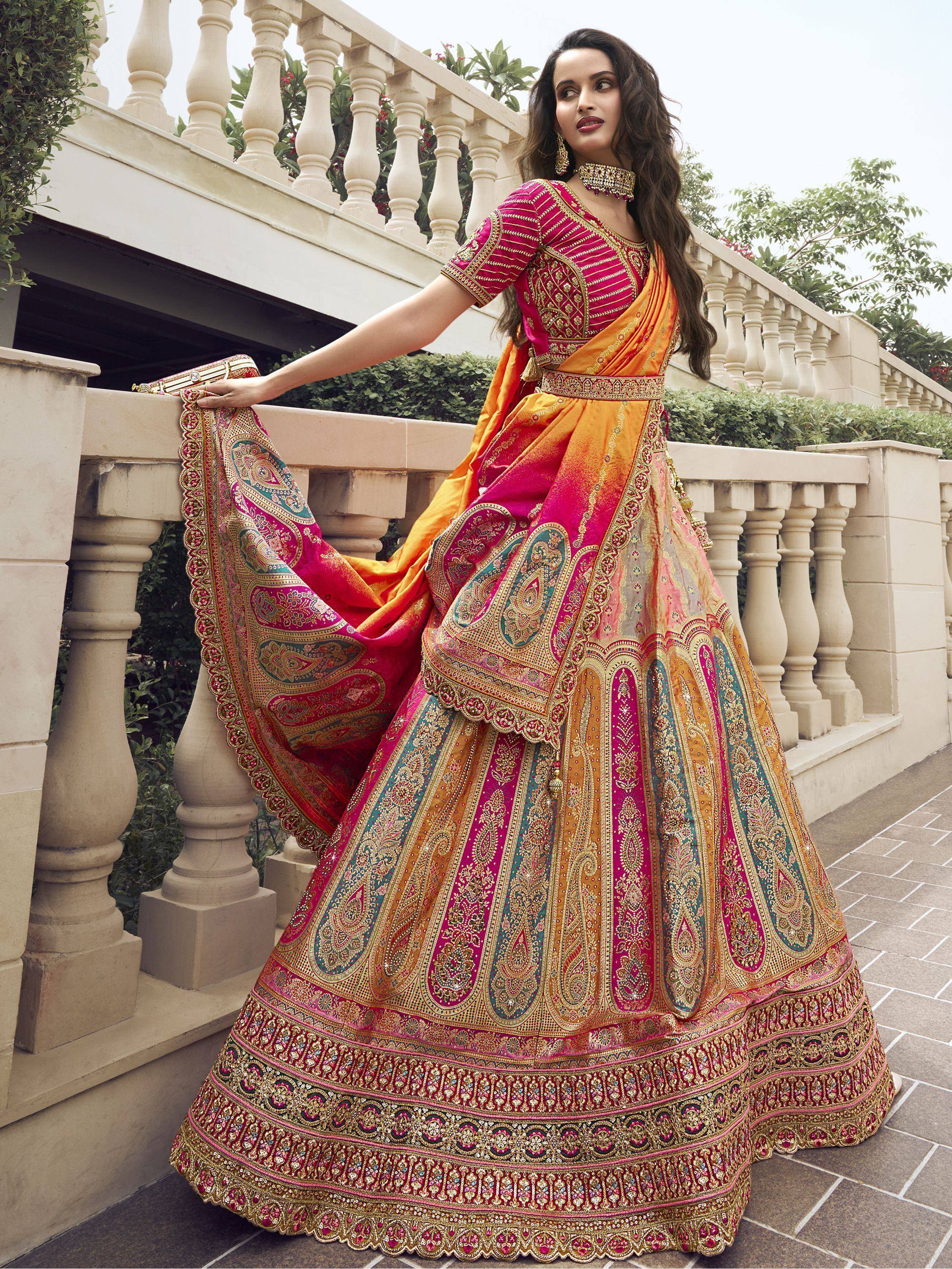 Designer lehenga choli in pink and orange with intricate embroidery and paisley patterns, perfect for Indian ethnic wear.